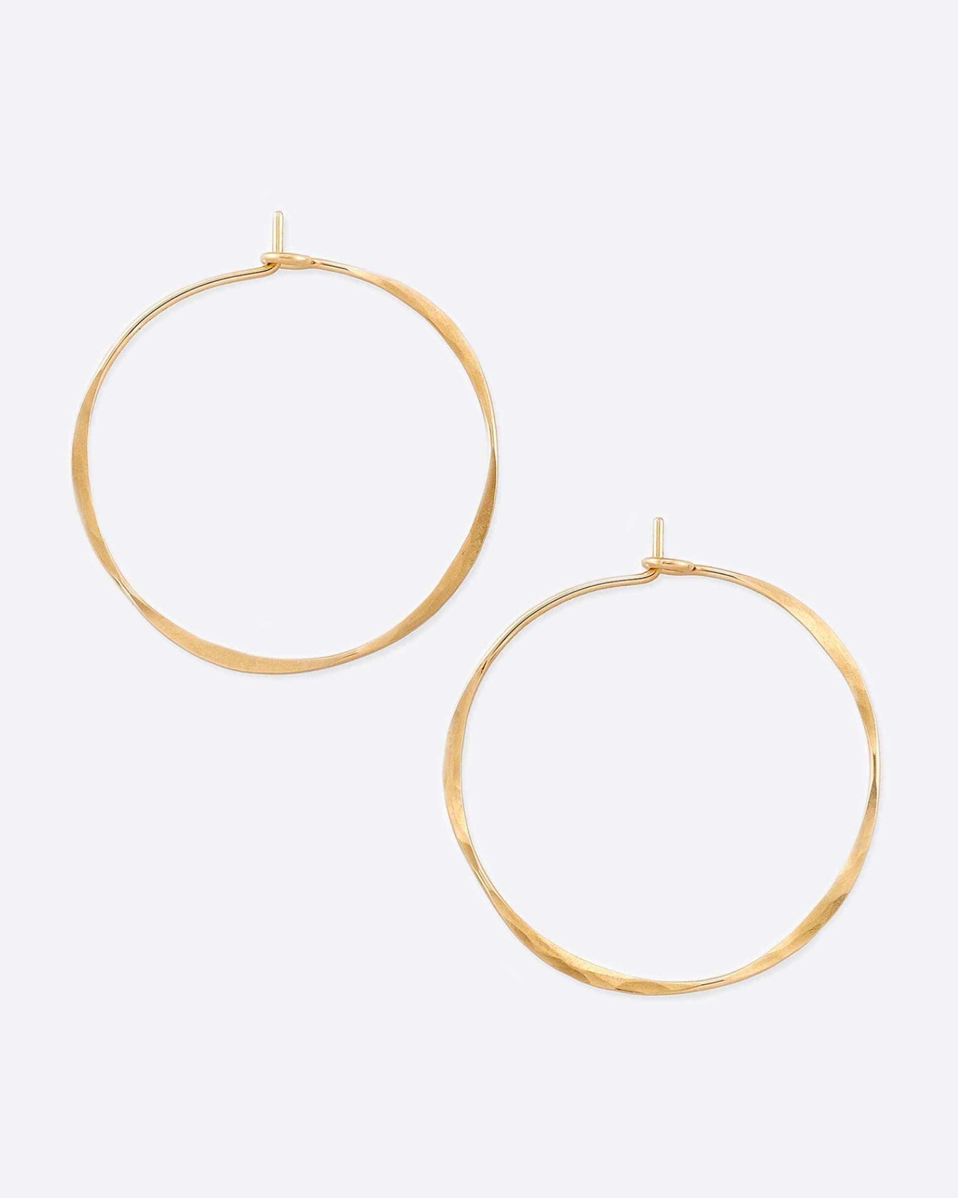 Hand-hammered yellow gold hoops with a comfortable hook closure.