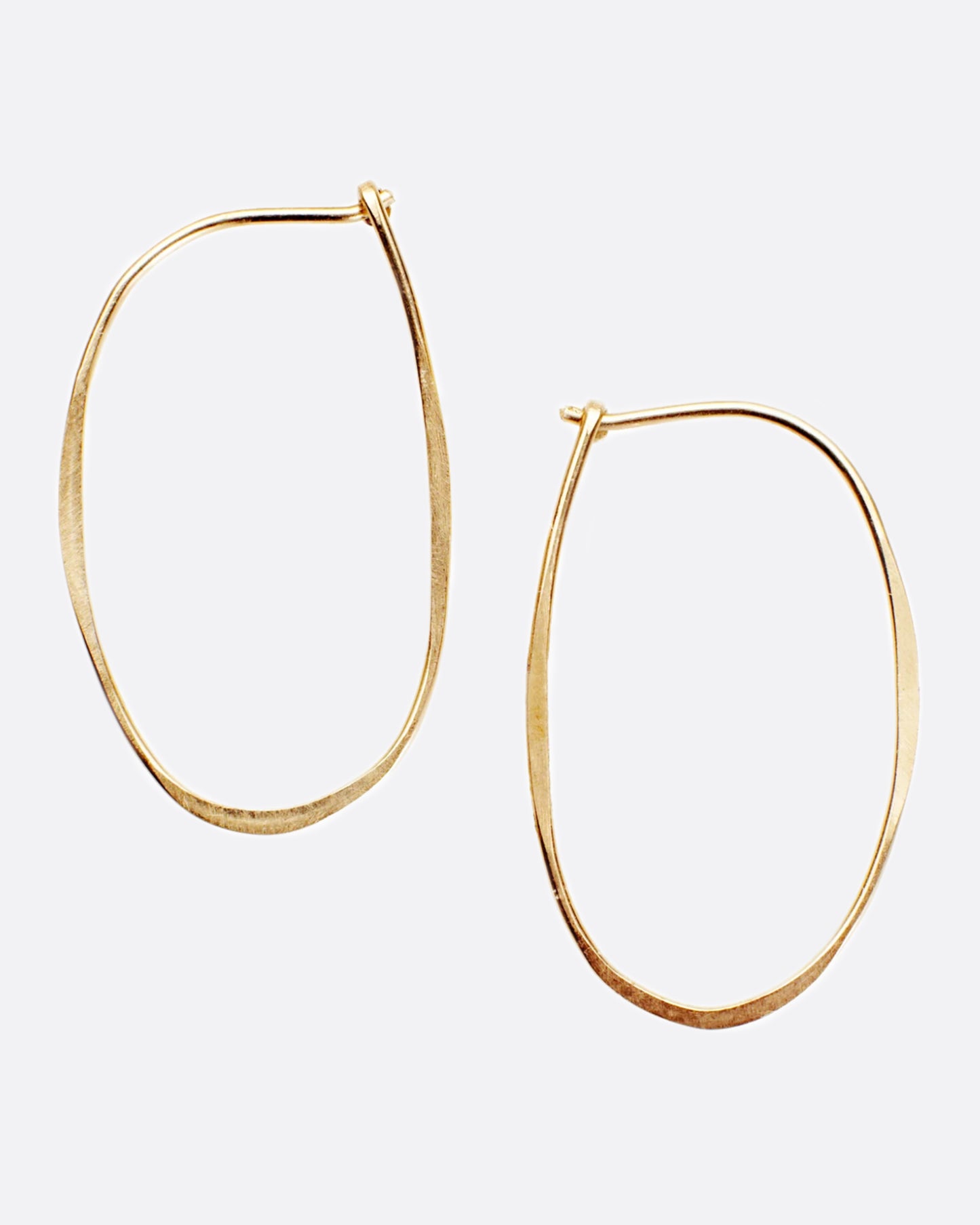 A pair of yellow gold, oval, hammered wire hoops with a hook closure.