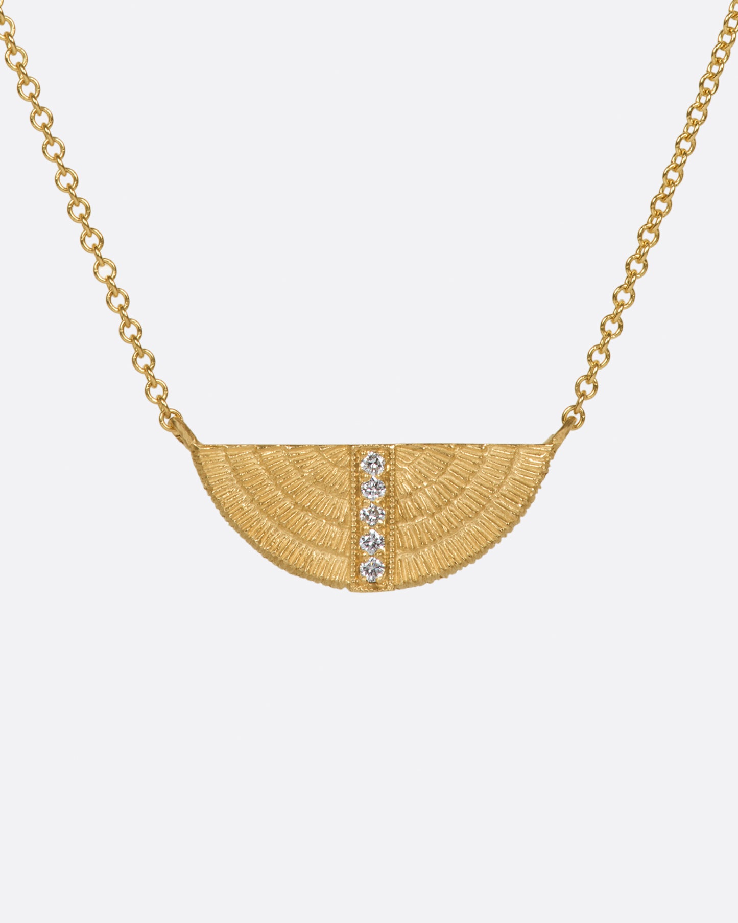 A semi-circular, textured pendant with a row of white diamonds.