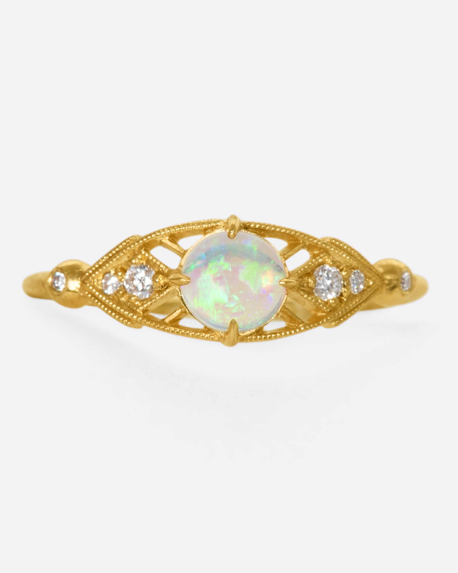 A glowy opal flanked with tiny, sparkly, diamonds, and set on a delicate band 14k gold band