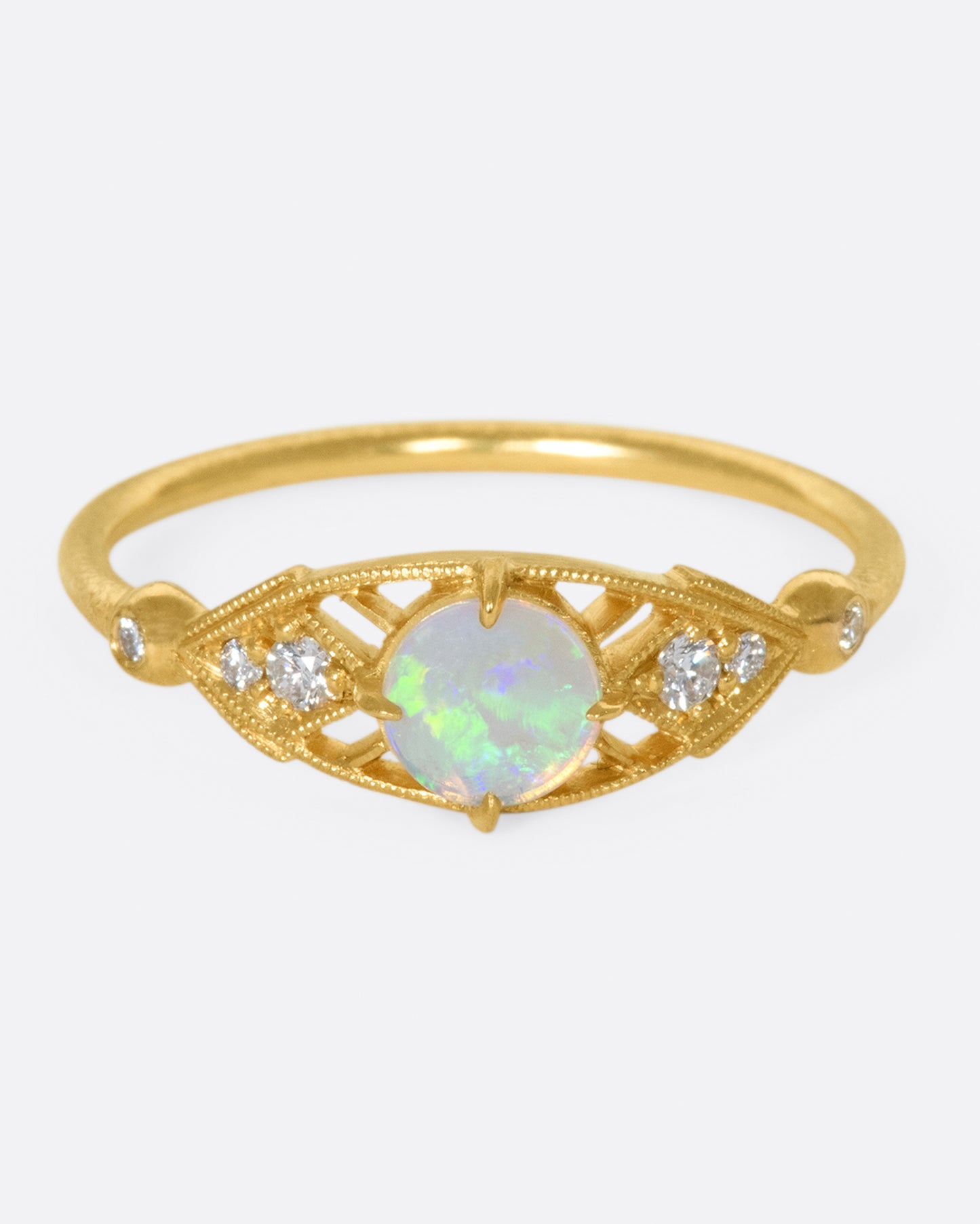 A glowy opal flanked with tiny, sparkly, diamonds, and set on a delicate band 14k gold band