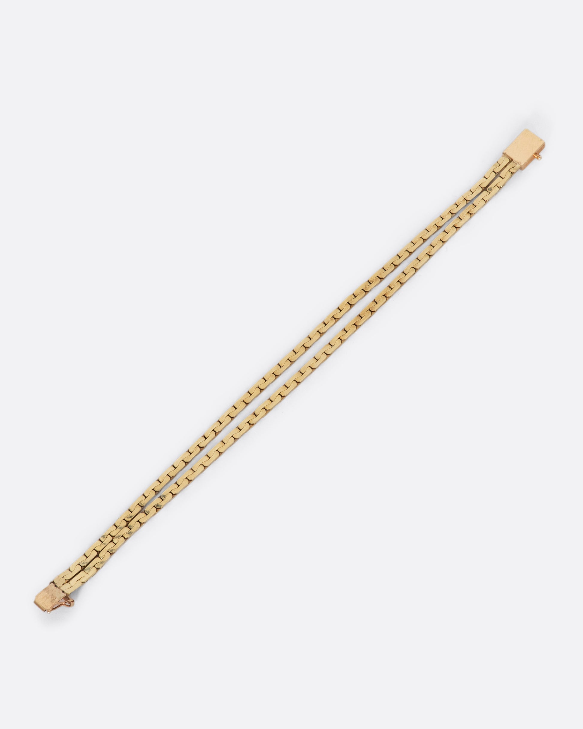 Yellow gold double strand flat cable link chain bracelet. View laying flat from above, showing separation in the chain.