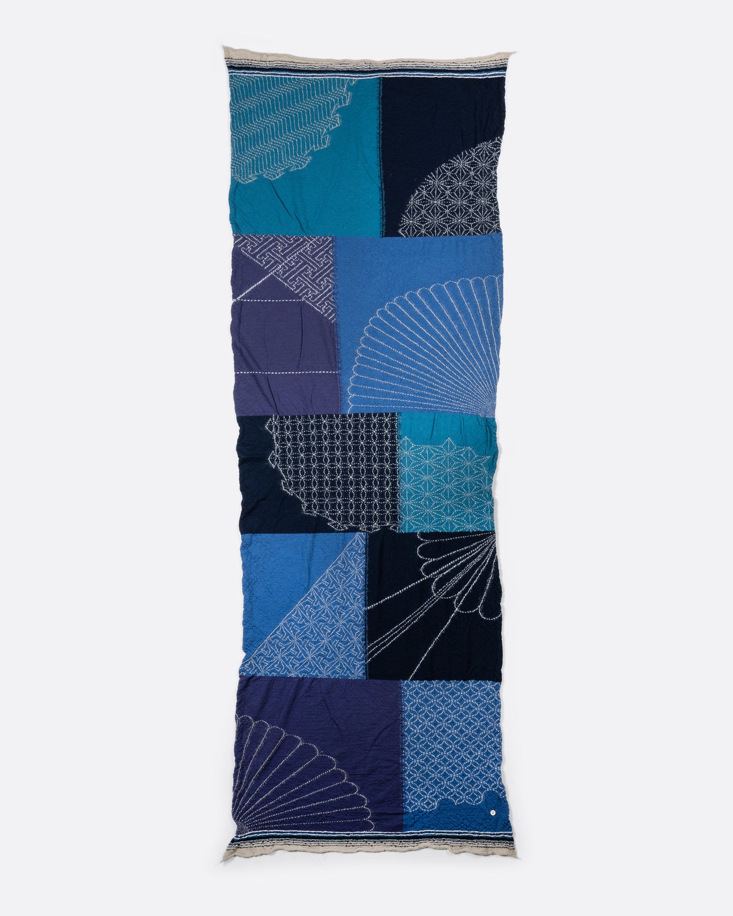 A blue patchwork scarf. View laying flat.