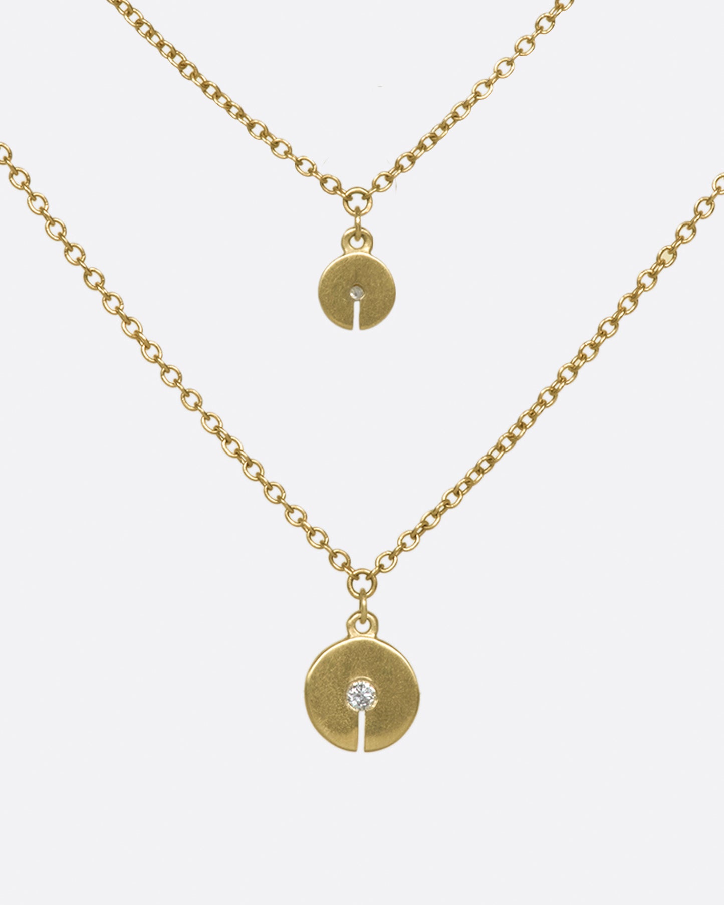 A double-layer 10K gold necklace with two grey diamond discs that elegantly dot your neck.