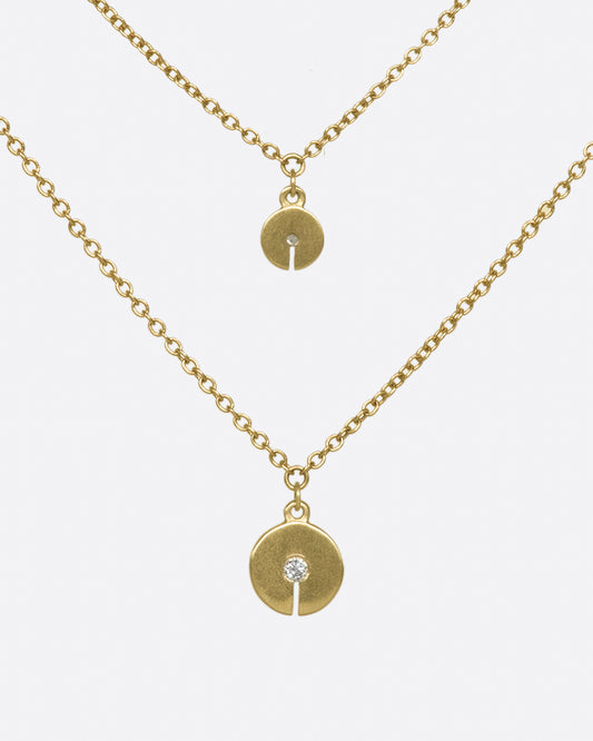 A double-layer 10K gold necklace with two grey diamond discs that elegantly dot your neck.