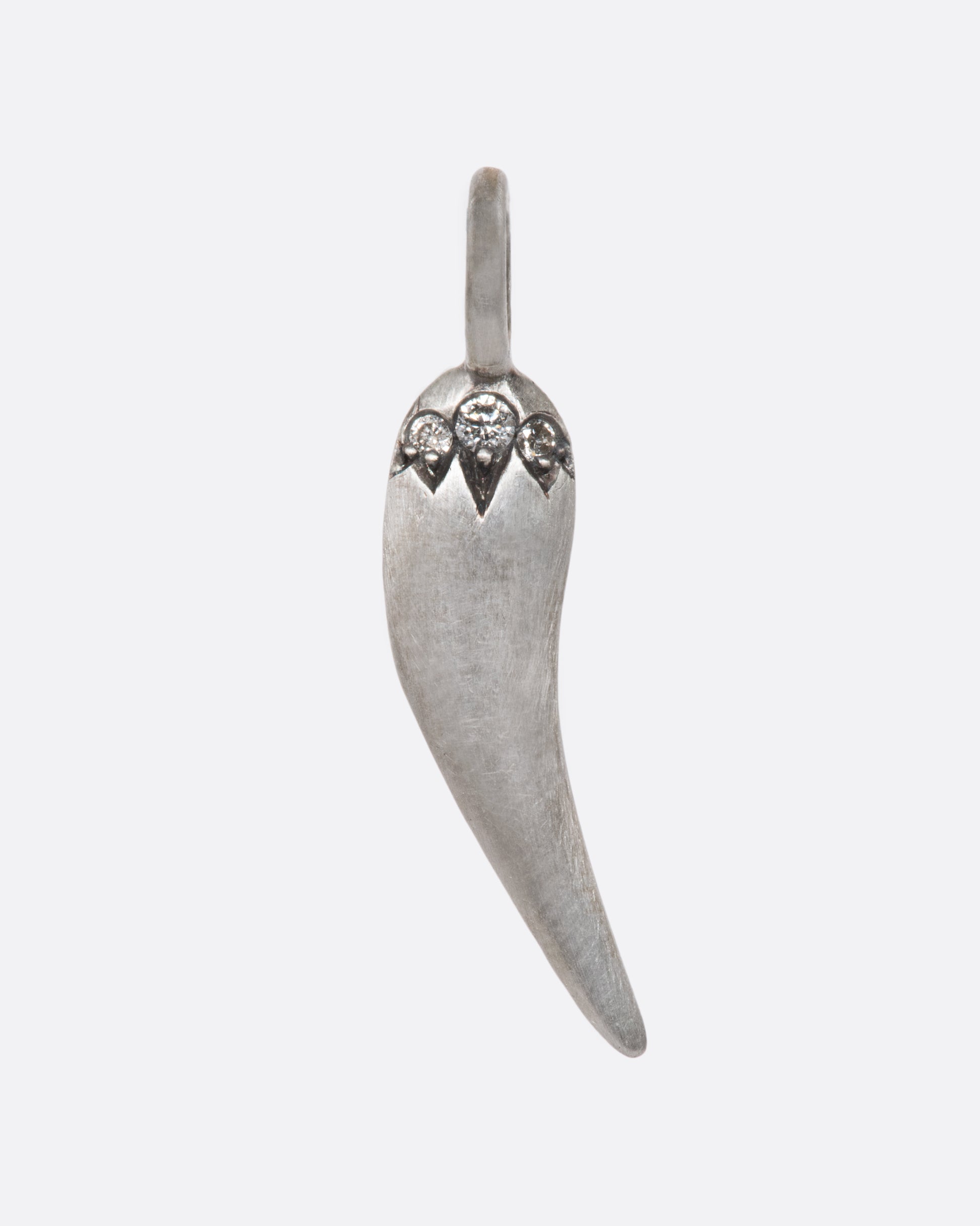 A spicy, sterling silver pepper charm with a matte finish, superbly shiny grey diamonds, and a razor thin edge. Serving sass in all the right ways.