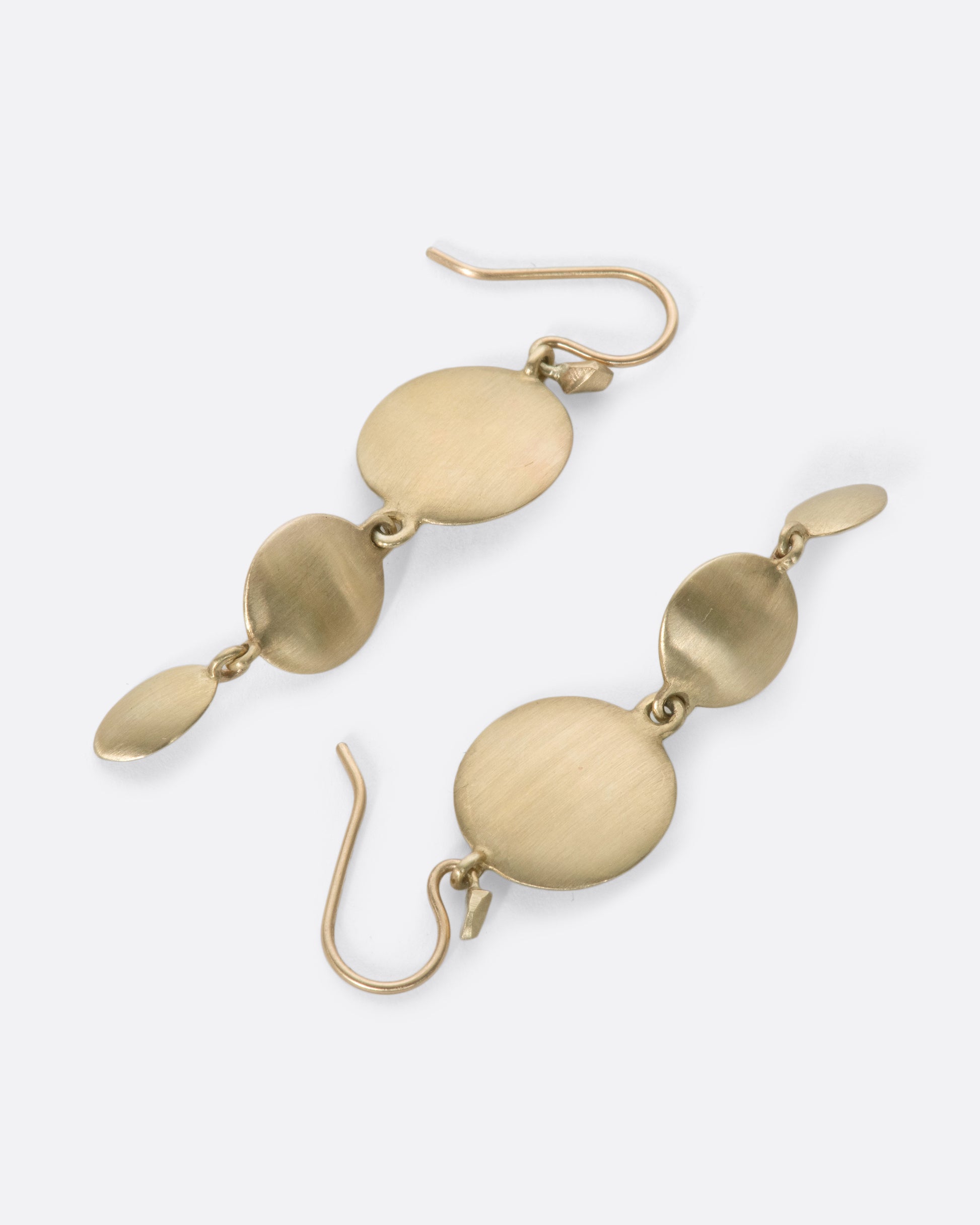 These unusual triple drop brushed gold earrings have impressive razor thin edges that make them look different from every angle