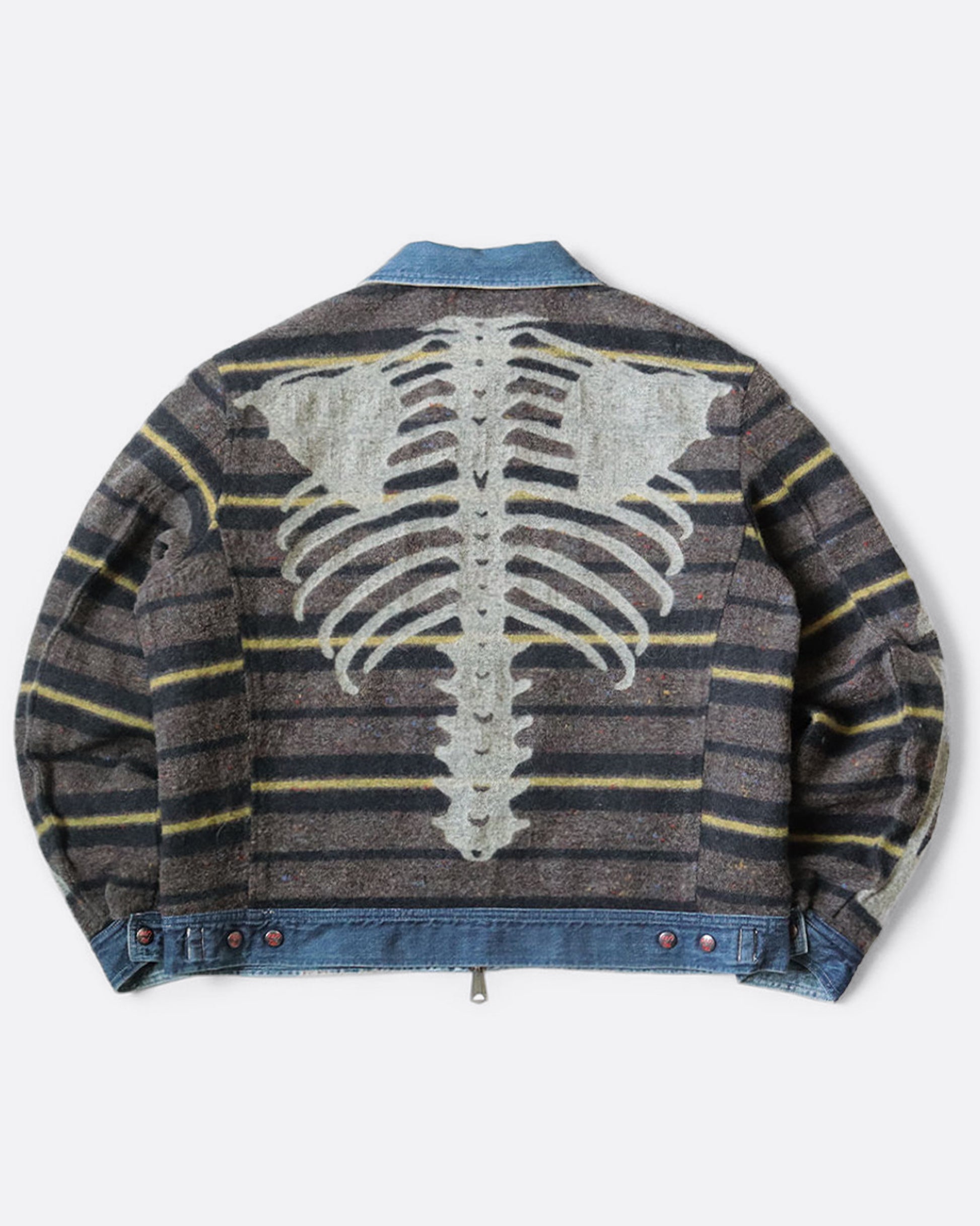 A blue denim work jacket with a beige collar, lined in wool with a skeleton print. Shown from the back, reversed.