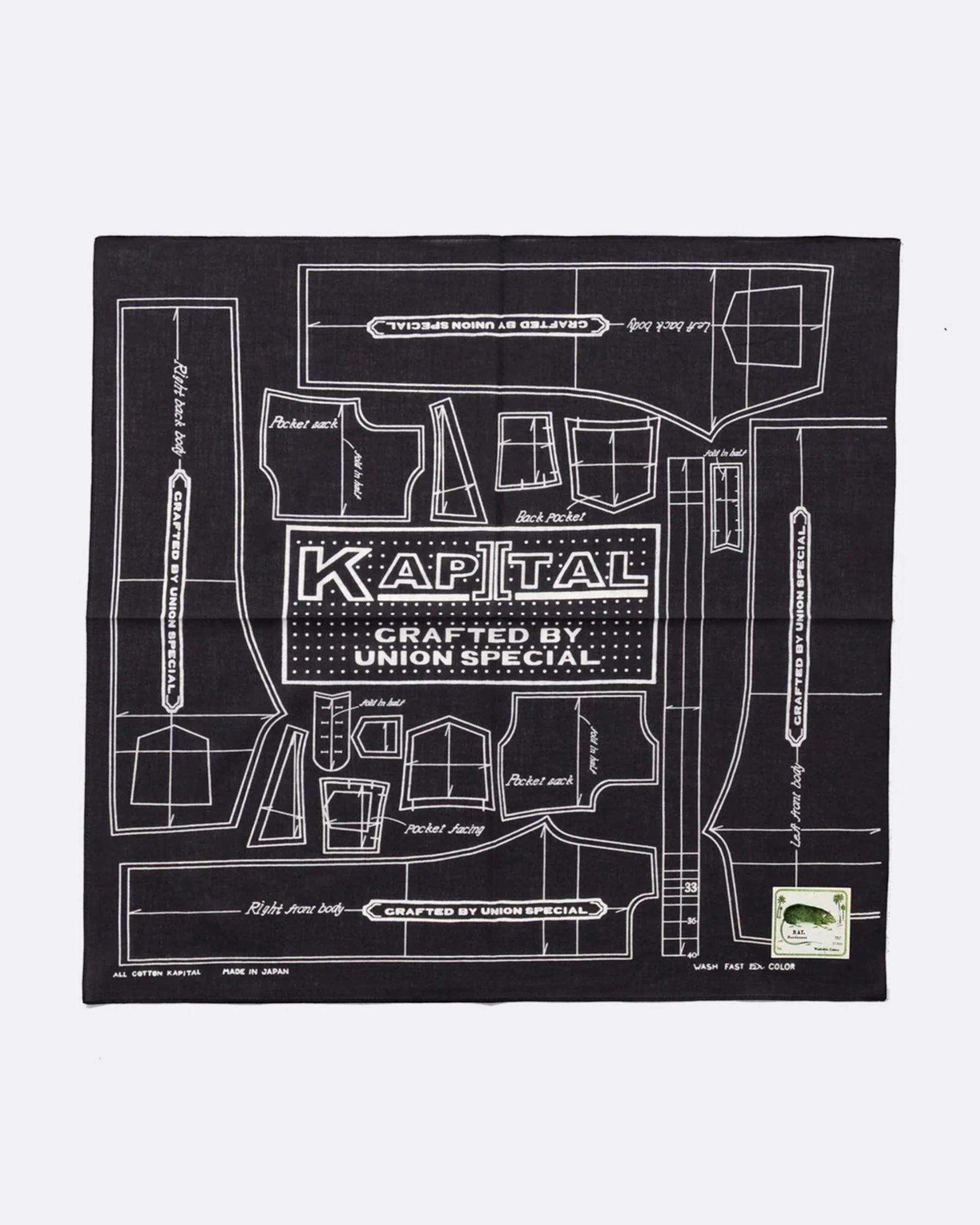 A black cotton bandana with a  pattern for a Barbie sized outfit in white and 'KAPITAL CRAFTED BY UNION SPECIAL' at the center. Shown from the front.
