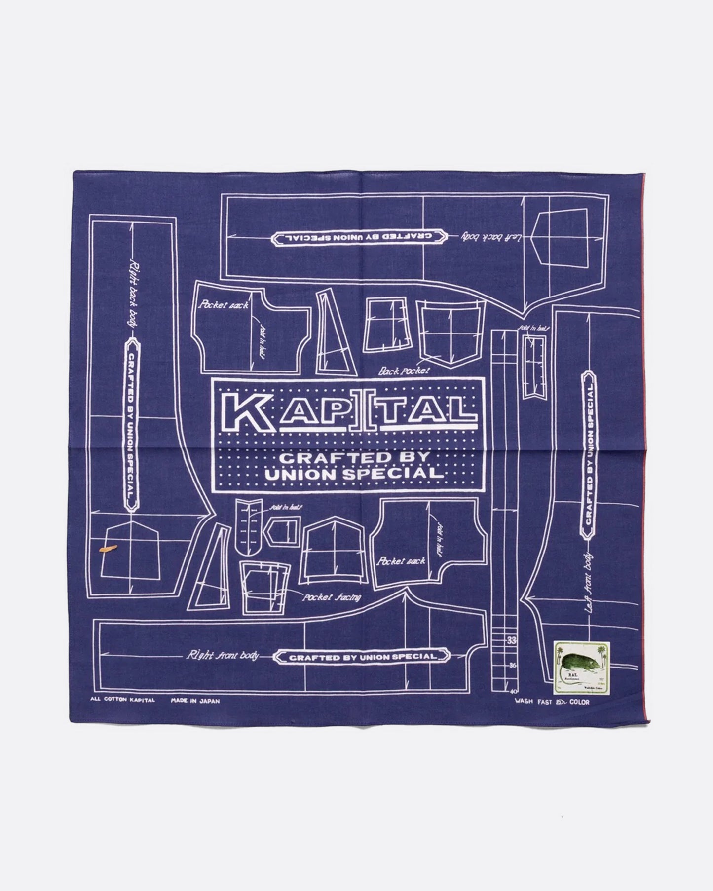 A purple cotton bandana with a  pattern for a Barbie sized outfit in white and 'KAPITAL CRAFTED BY UNION SPECIAL' at the center. Shown from the front.