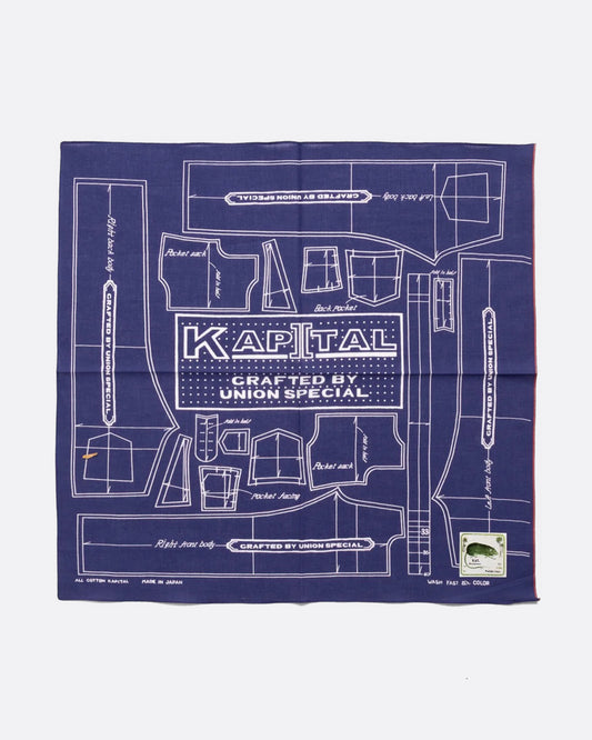 A purple cotton bandana with a  pattern for a Barbie sized outfit in white and 'KAPITAL CRAFTED BY UNION SPECIAL' at the center. Shown from the front.