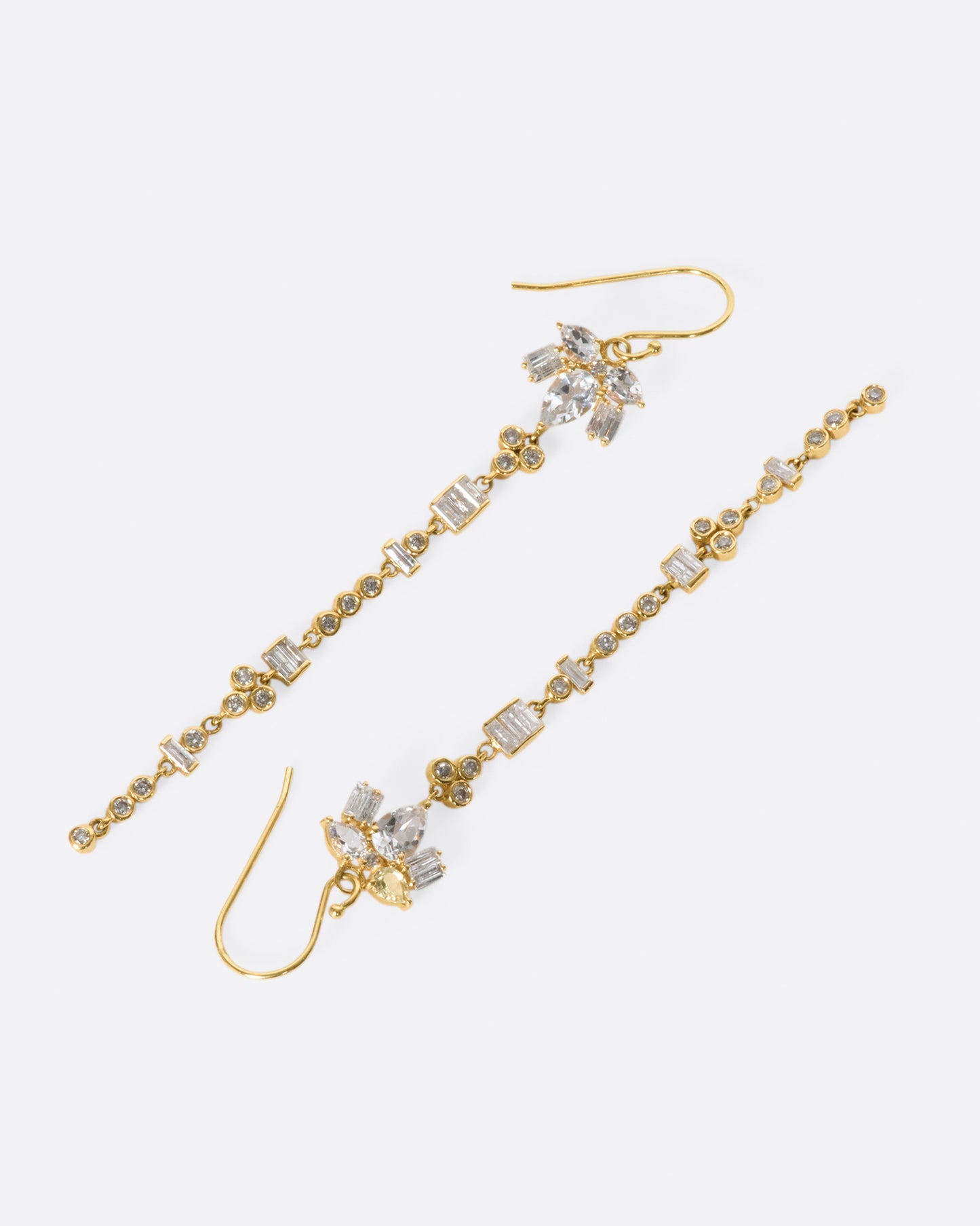 A pair of 14k gold drop earrings with a geometric variety of white topaz and diamonds.