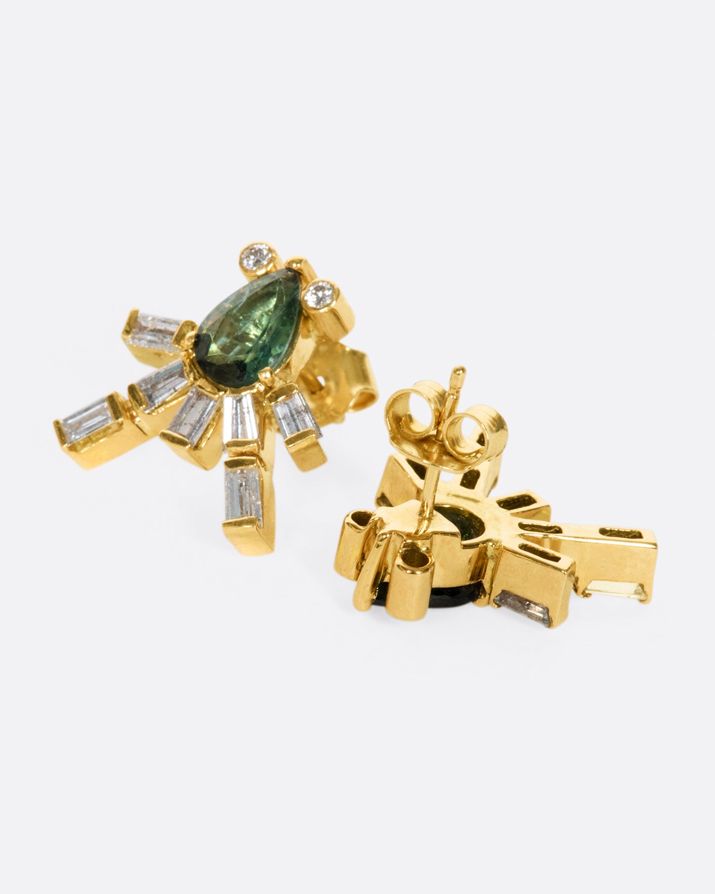 This gorgeous green tourmaline earring is swimming with sage and rich forrest green tones. Round diamond accents and glimmering baguettes light up beneath your lobe, creating an elegant, regal look.