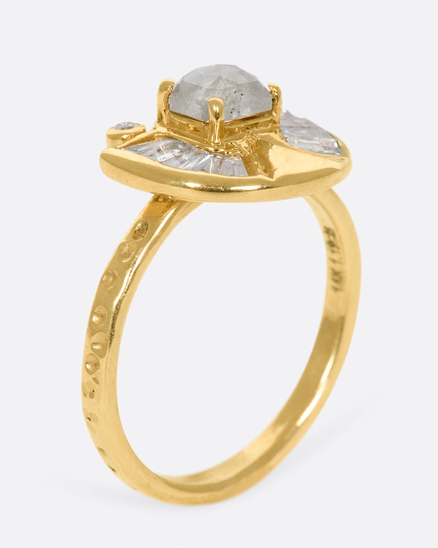 A textured gold ring with a rose cut salt & pepper diamond at its center surrounded by round and baguette diamond accents.