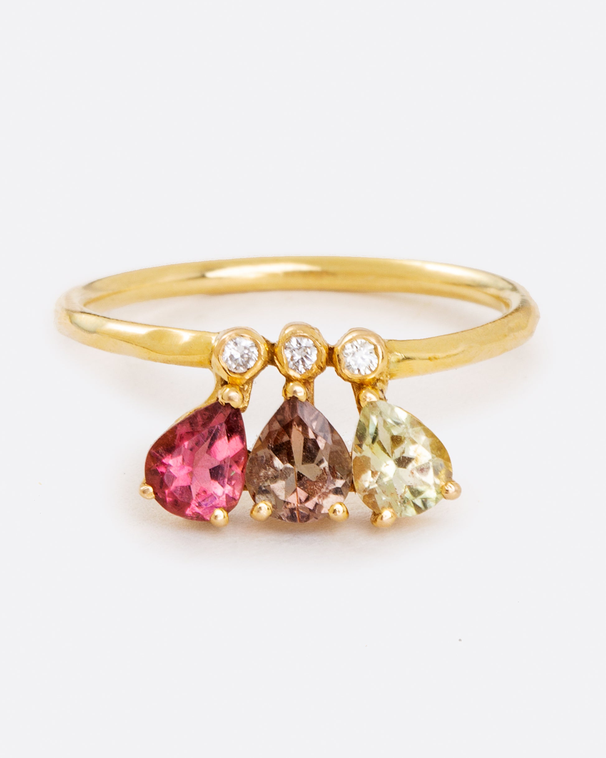 A crown of pear shaped green, red, and pink tourmalines leap from bezel set diamonds on a thin, solid 14 karat gold band.