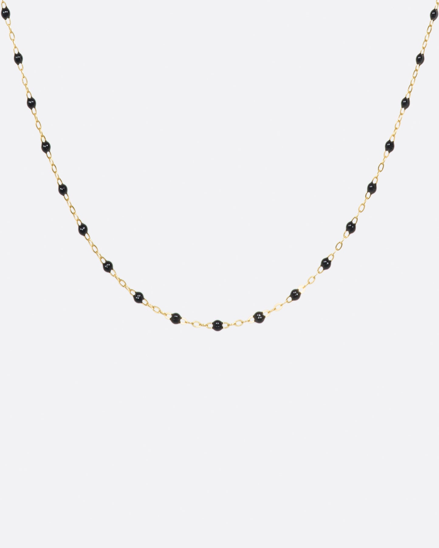 A thin yellow gold chain necklace with resin beads. Each necklace is hand dipped in melted resin to create the beaded effect. 