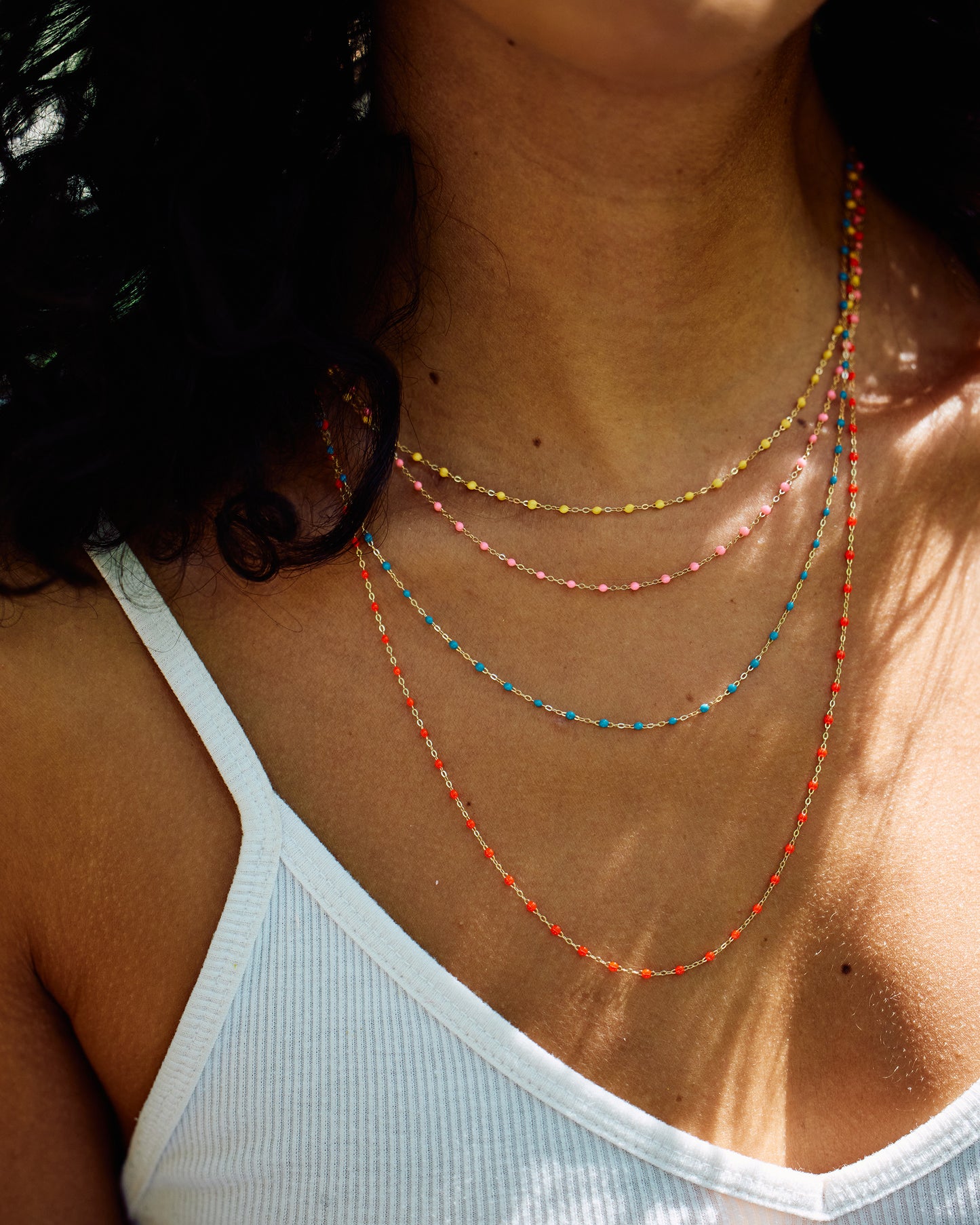 A thin yellow gold chain necklace with resin beads. Each necklace is hand dipped in melted resin to create the beaded effect. 