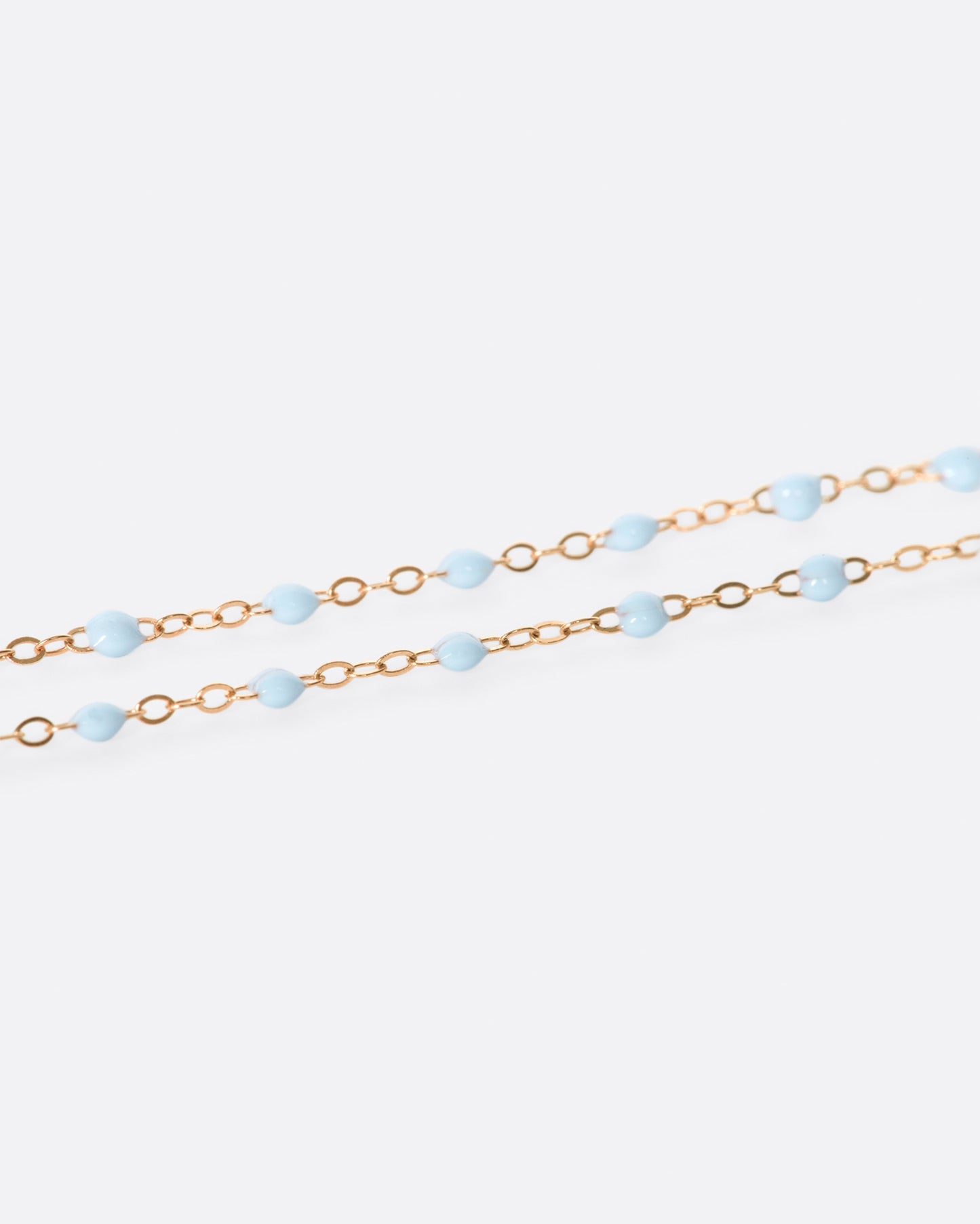 A thin rose gold chain necklace with resin beads. Each necklace is hand dipped in melted resin to create the beaded effect. 