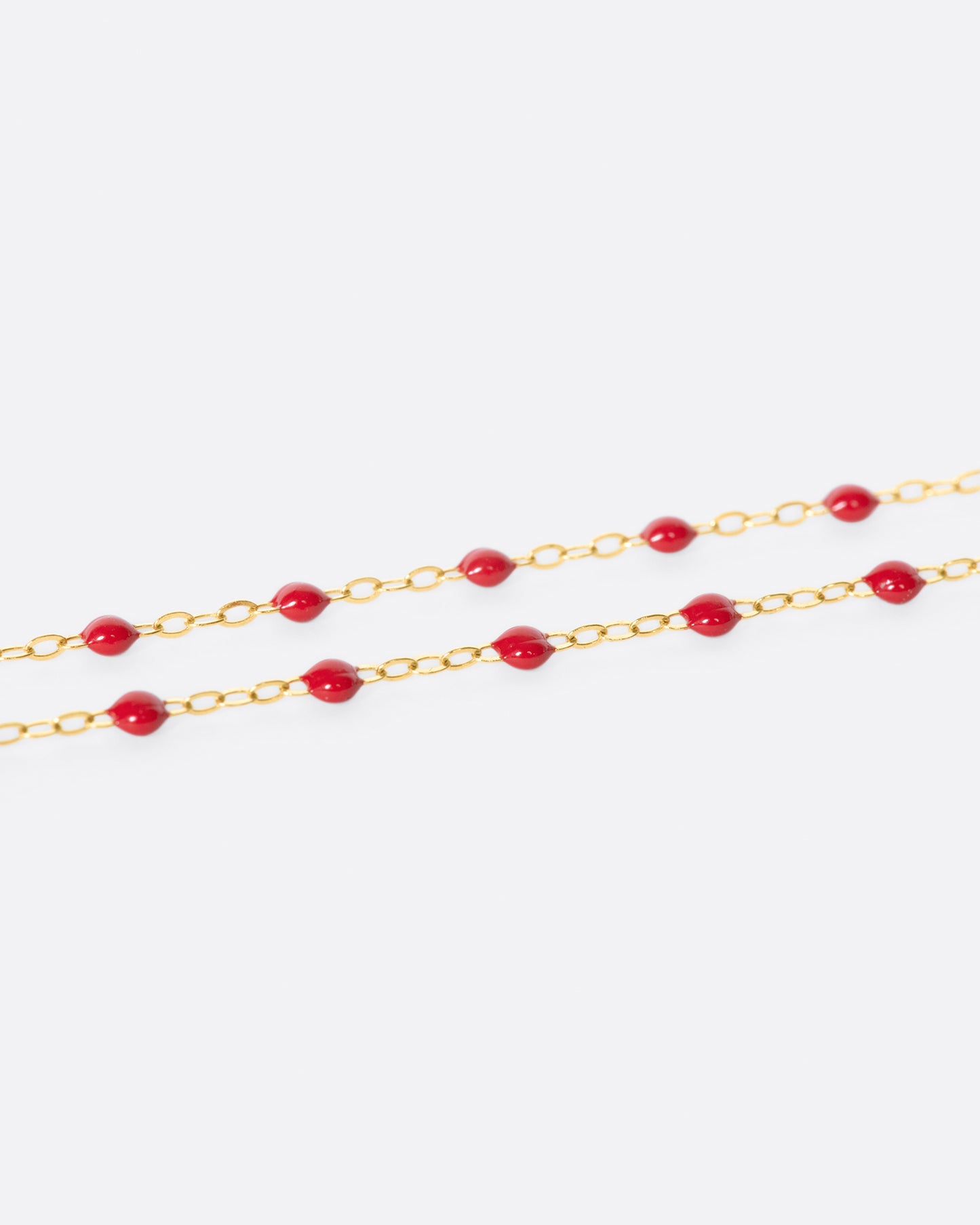 A thin yellow gold chain necklace with resin beads. Each necklace is hand dipped in melted resin to create the beaded effect. 