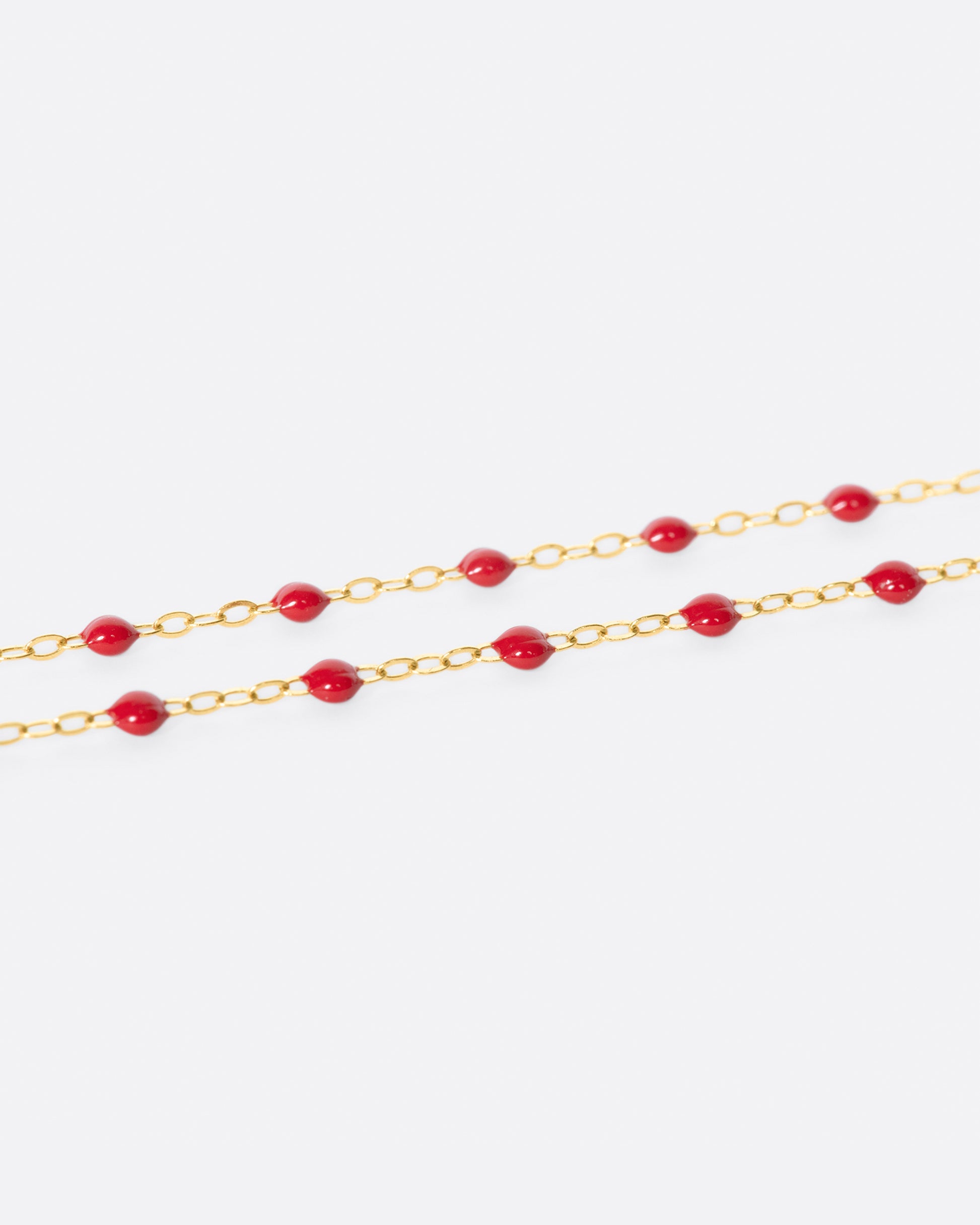 A thin yellow gold chain necklace with resin beads. Each necklace is hand dipped in melted resin to create the beaded effect. 