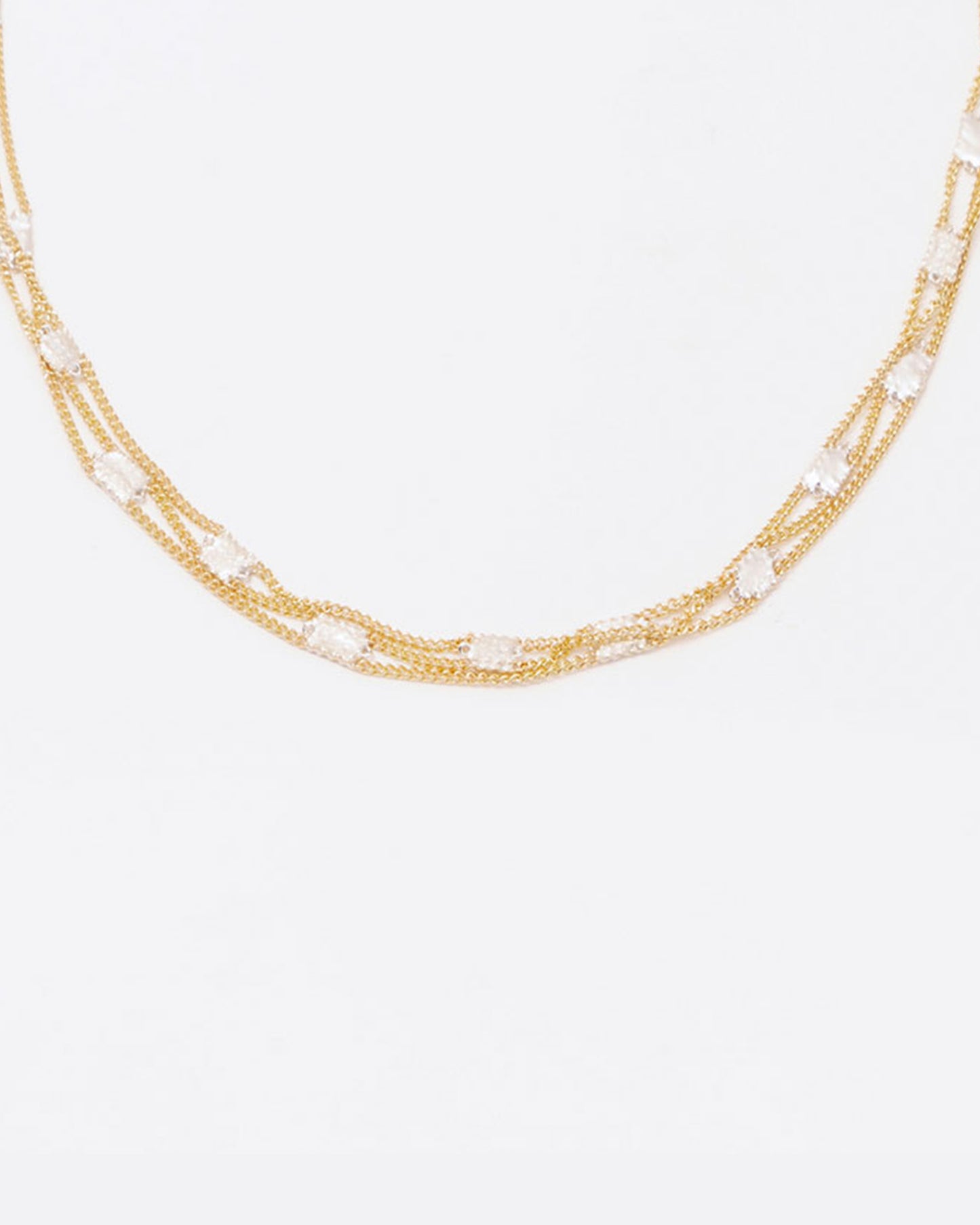 A necklace composed of three solid 18k yellow gold chains connected with sterling silver squares