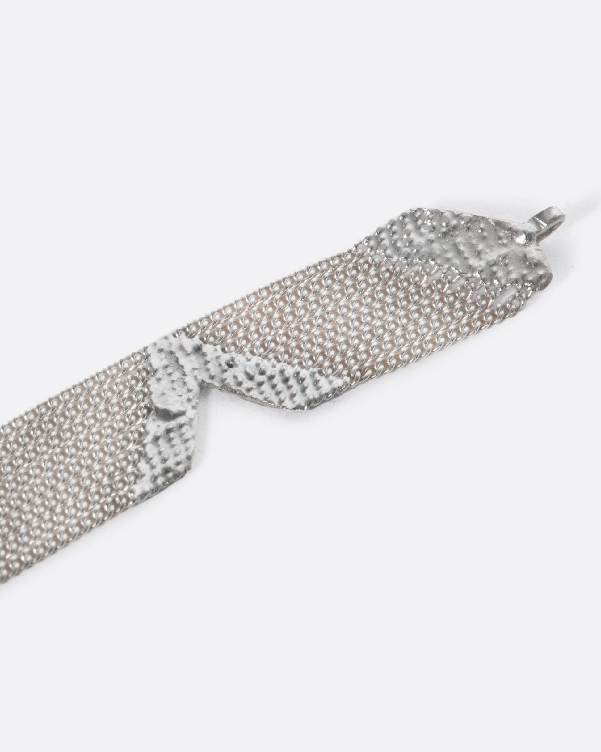 A sterling silver bracelet made out of multiple strands of chain, held together by solid sections of silver solder, with triangular cutouts along each side.