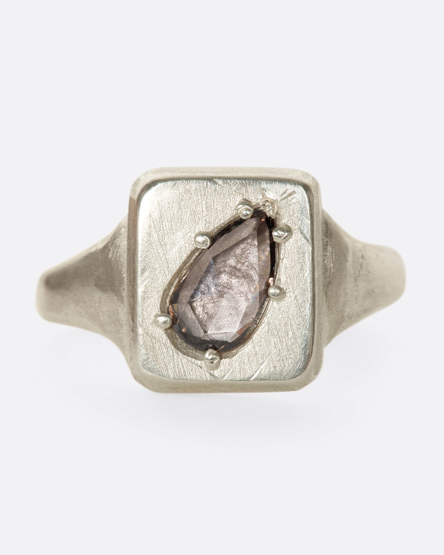 A handmade square signet ring with a cognac diamond sunken into it.