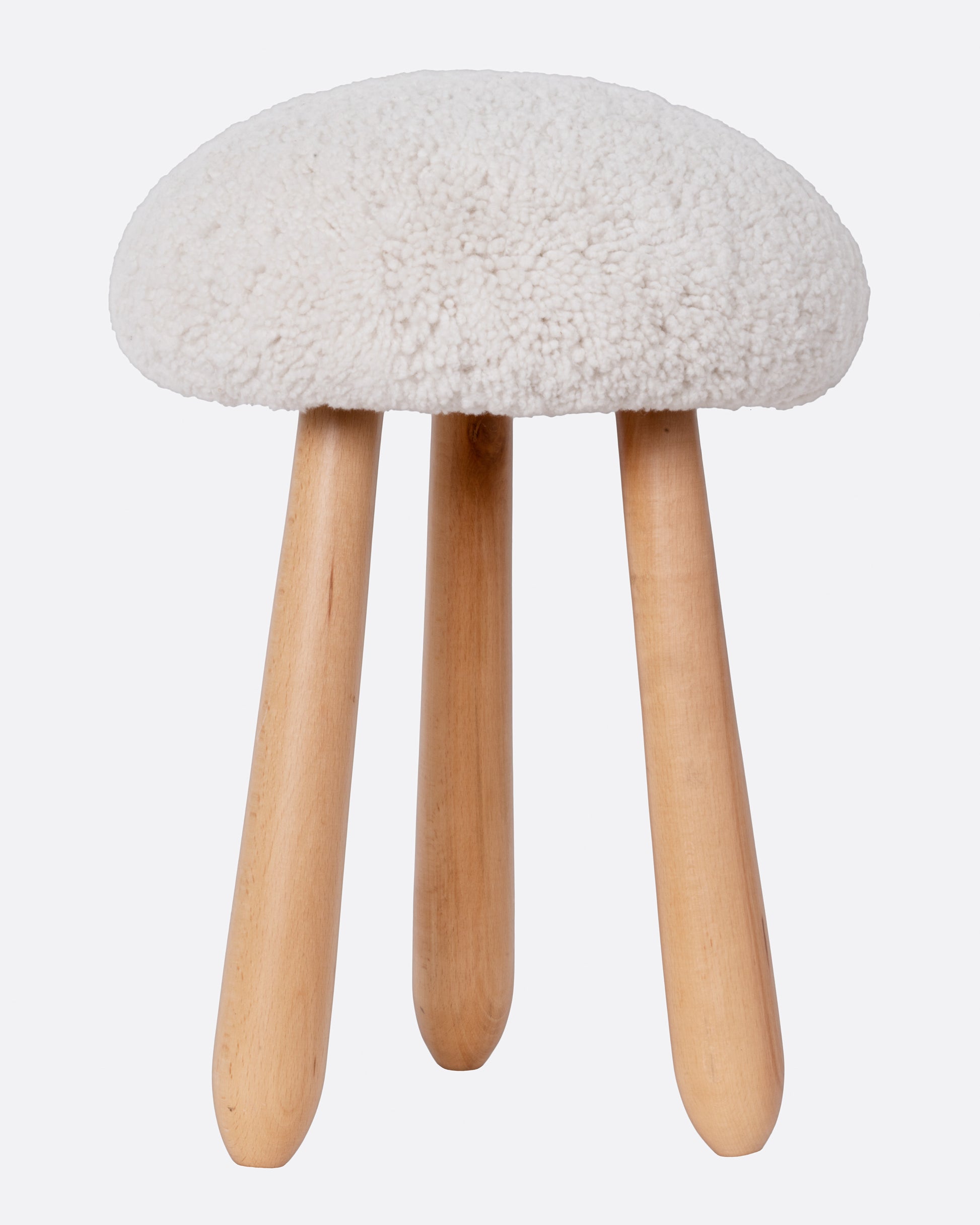 A domed shearling stool with three wooden legs, shown from the front.