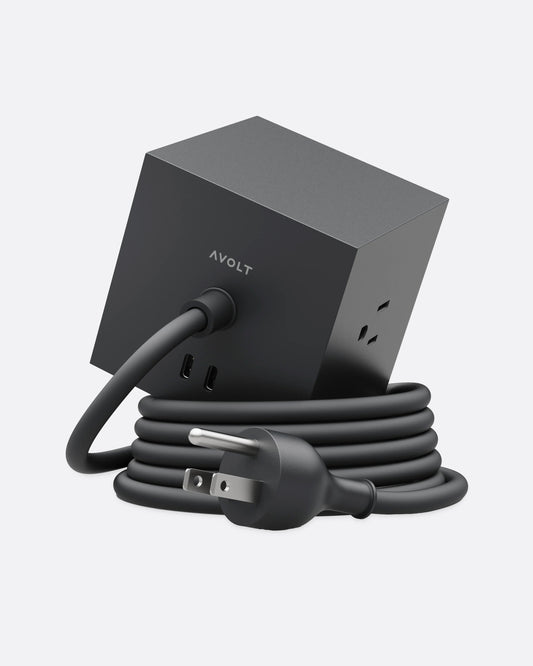 A black cube shaped power strip with multiple outlets and a coiled cable, shown from the back.