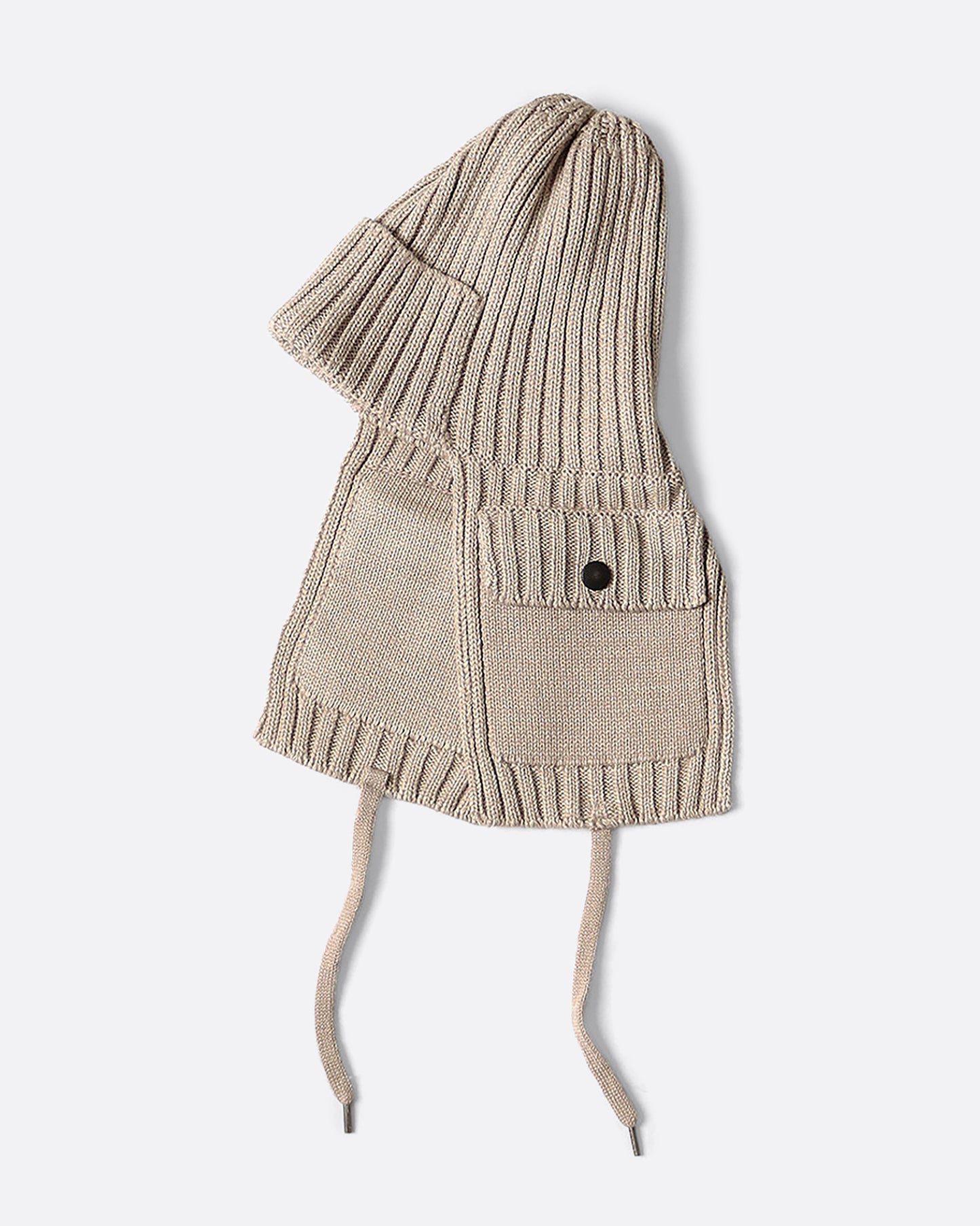 A beige knit hat with ear flaps and pockets. View from the side.