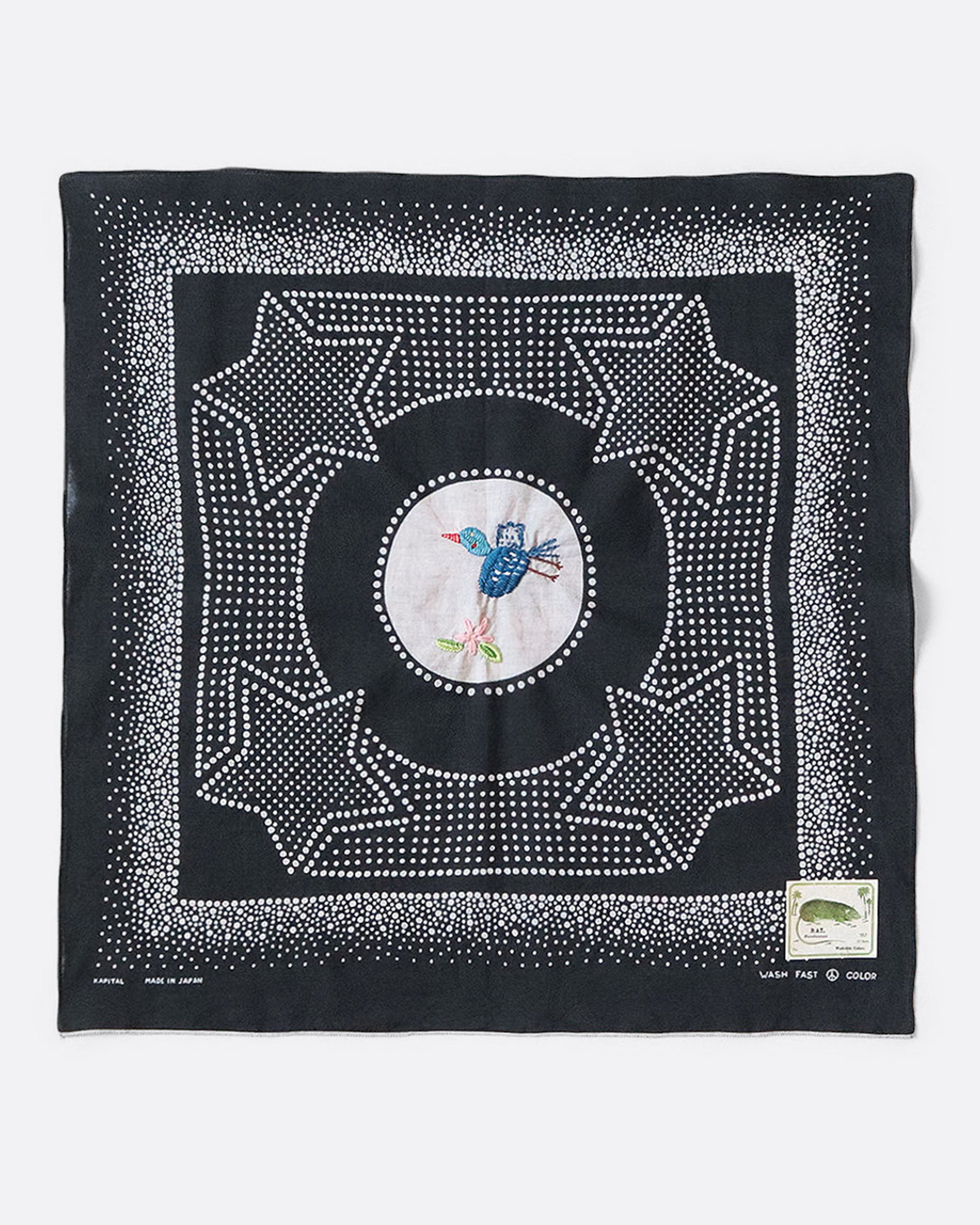 A black bandana with a spotted star motif and a hand- embroidered magpie at the center. Shown from the front. 