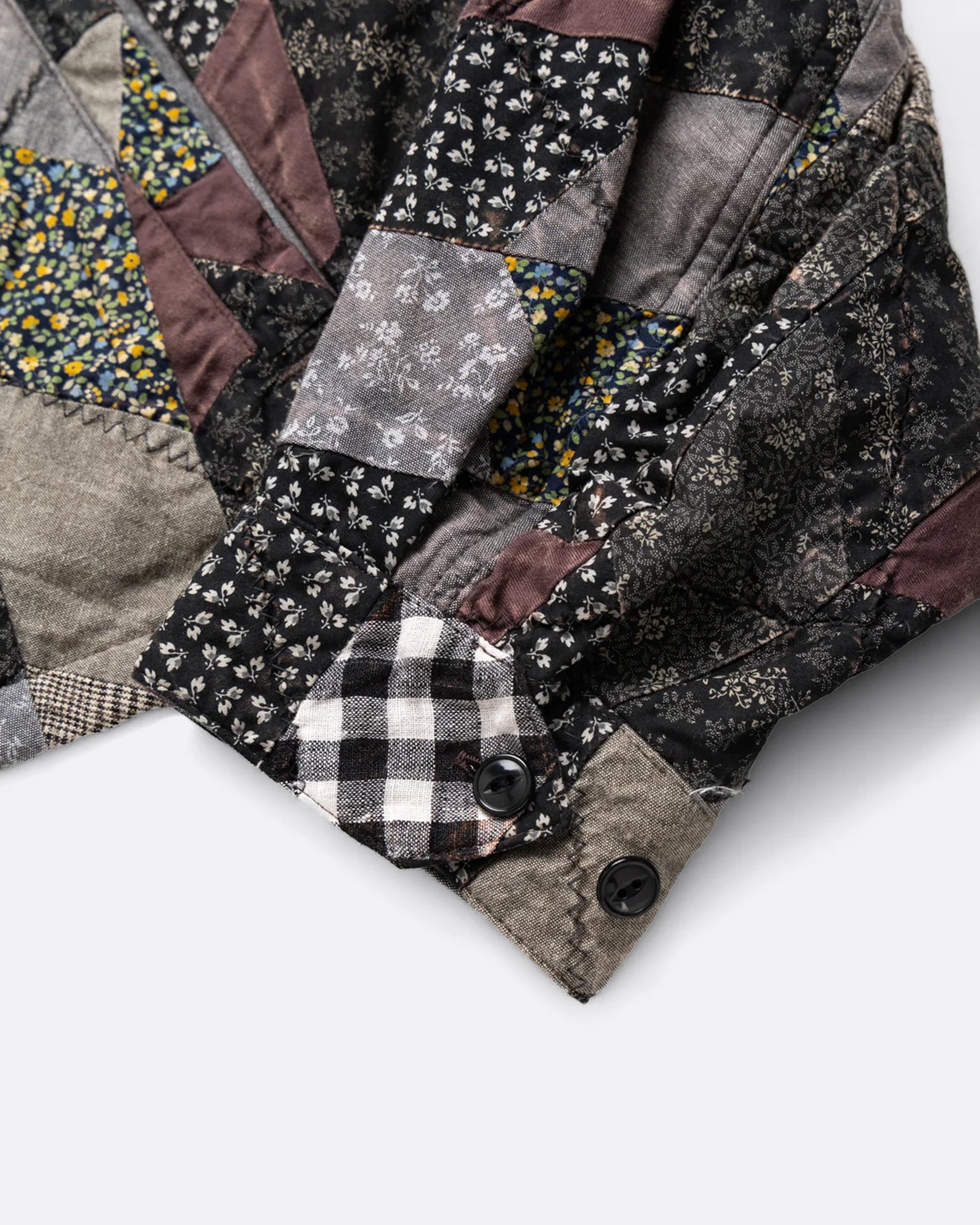 A close up of the cuff of a jacket with an arrow shaped patchwork.