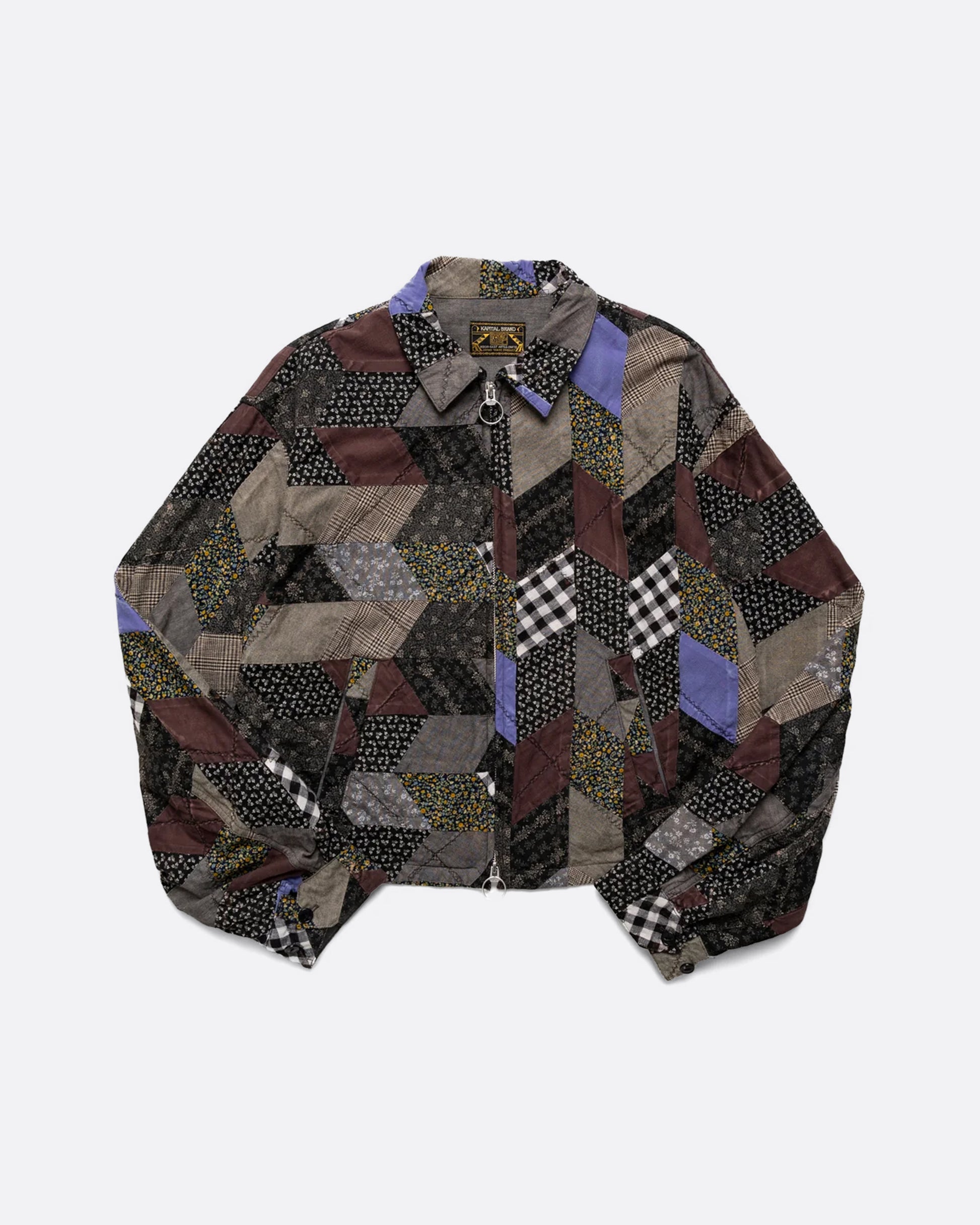 A cropped jacket with an arrow shaped patchwork and zip front. Shown from the front.