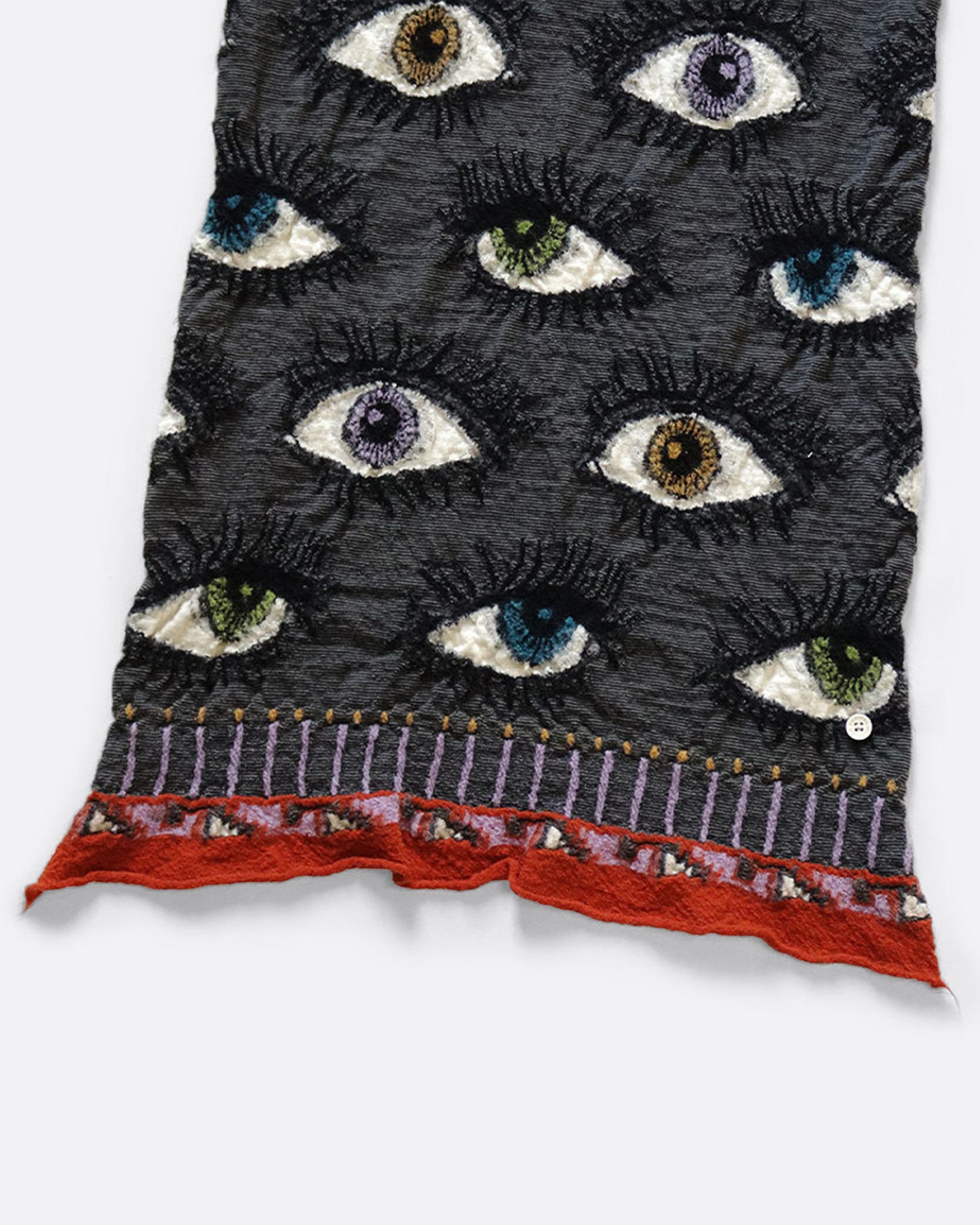 A close up of a charcoal gray compressed wool scarf with an all- over eye pattern.