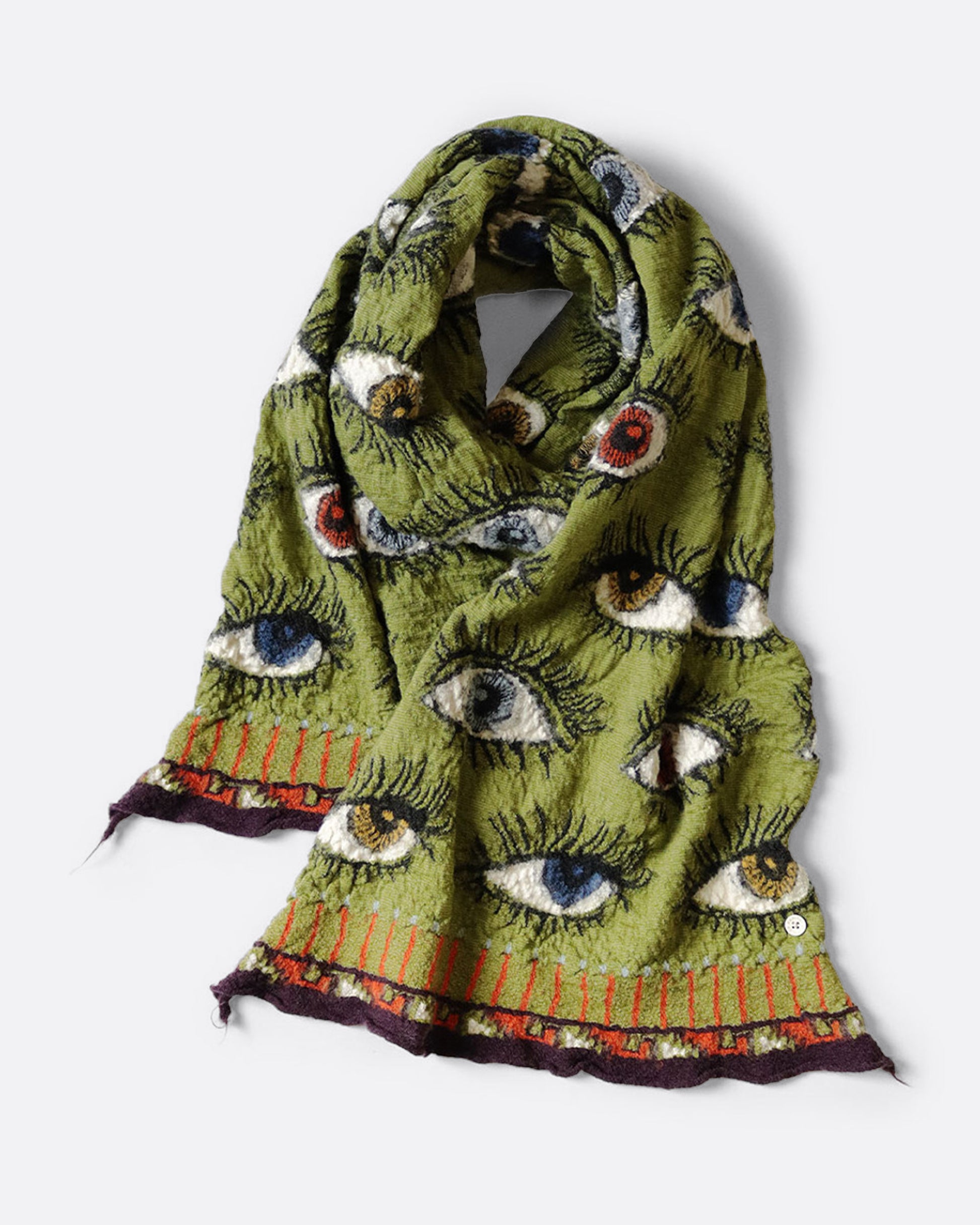A green compressed wool scarf with an all- over eye pattern, shown wrapped with one loop in the middle.