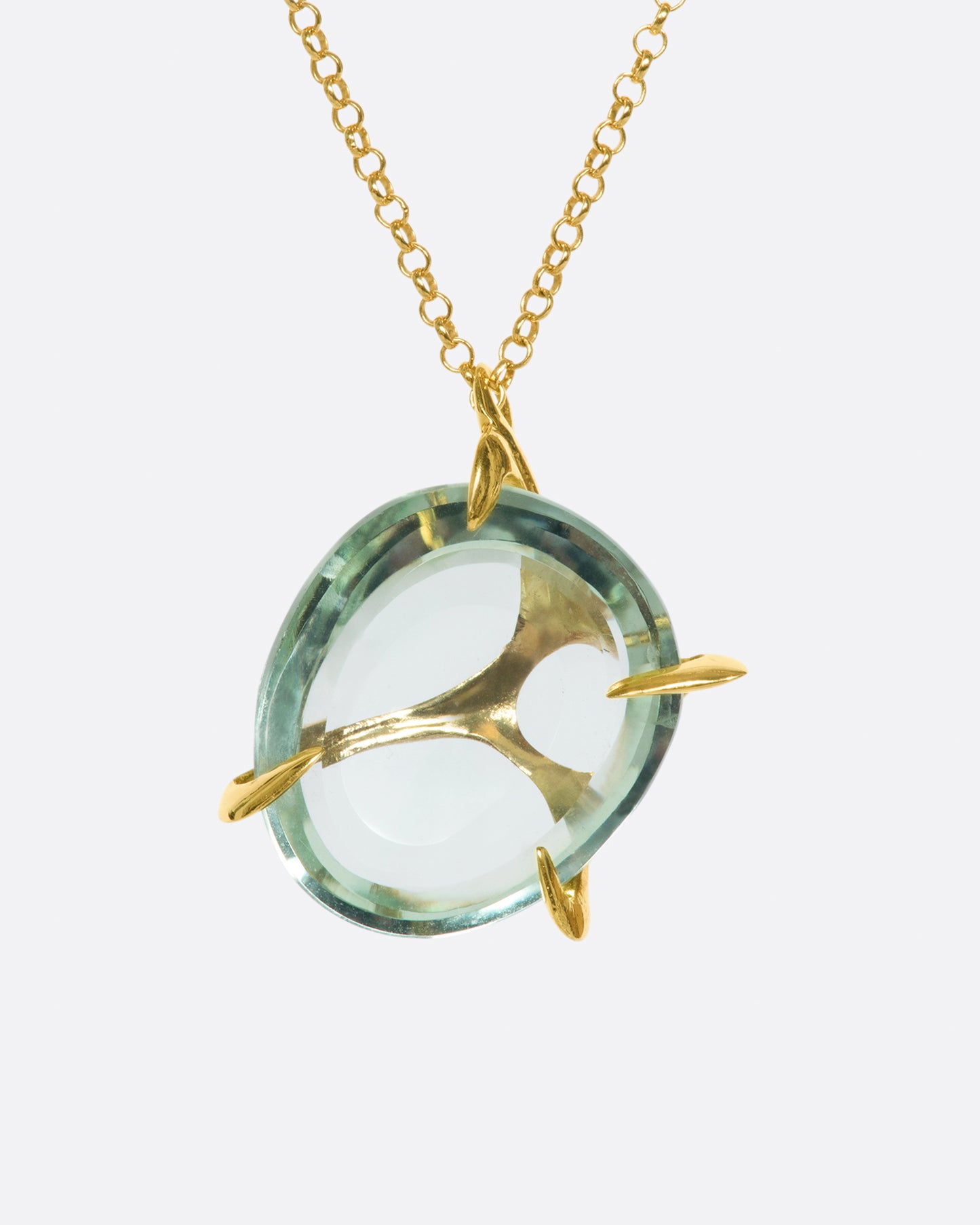 A yellow gold chain necklace with a large, round green quartz pendant set in large gold prongs.