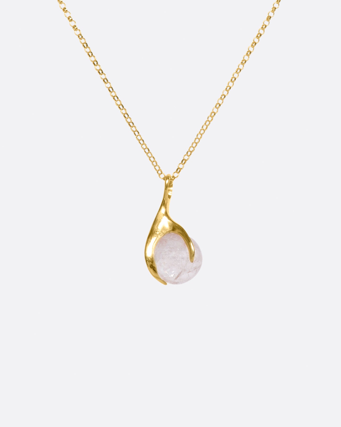 A pale pink tourmaline sphere is set in a gold claw setting for a substantial, yet airy pendant.