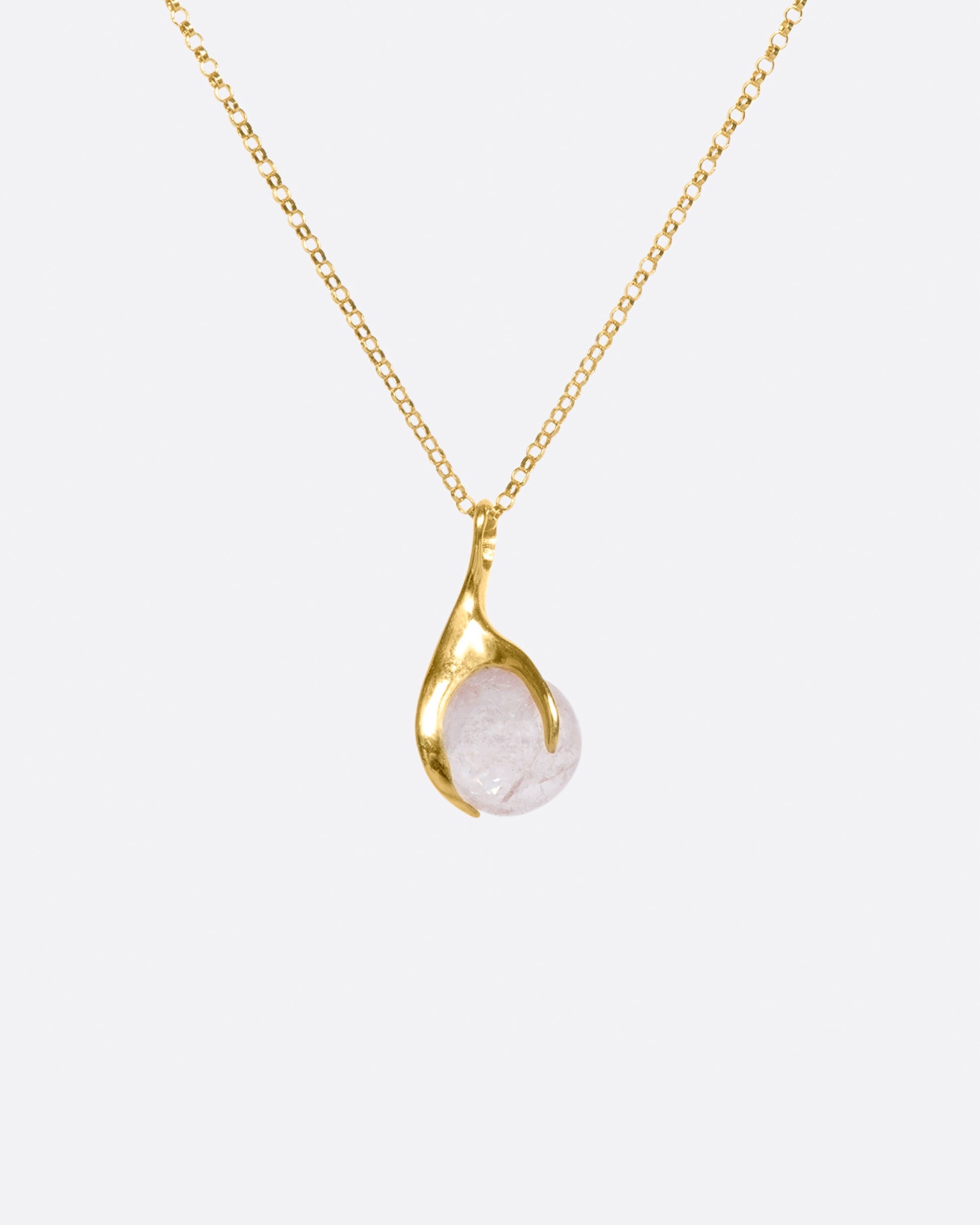 A pale pink tourmaline sphere is set in a gold claw setting for a substantial, yet airy pendant.