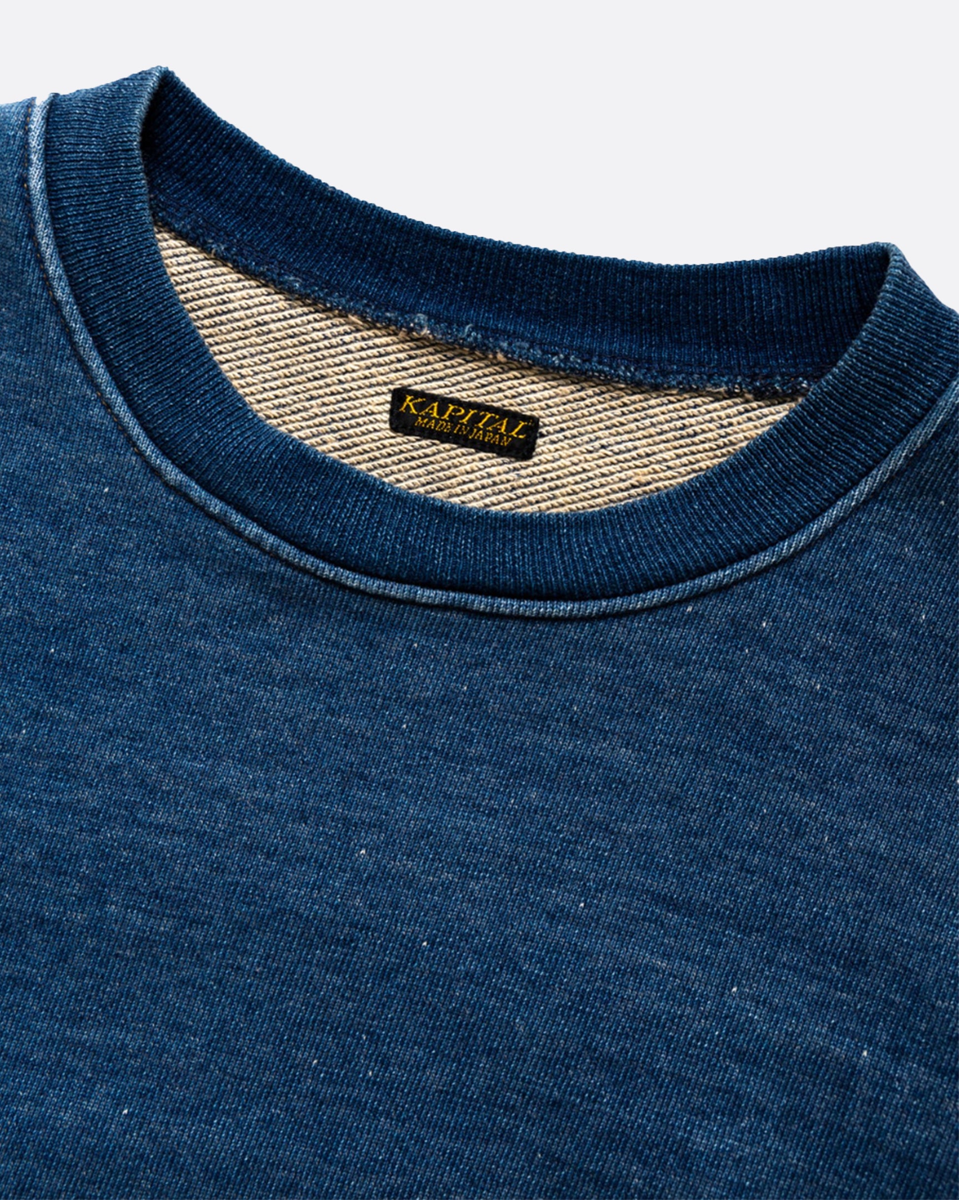 A loose fitting, indigo fleece sweatshirt with a T-shaped split back and cinch.