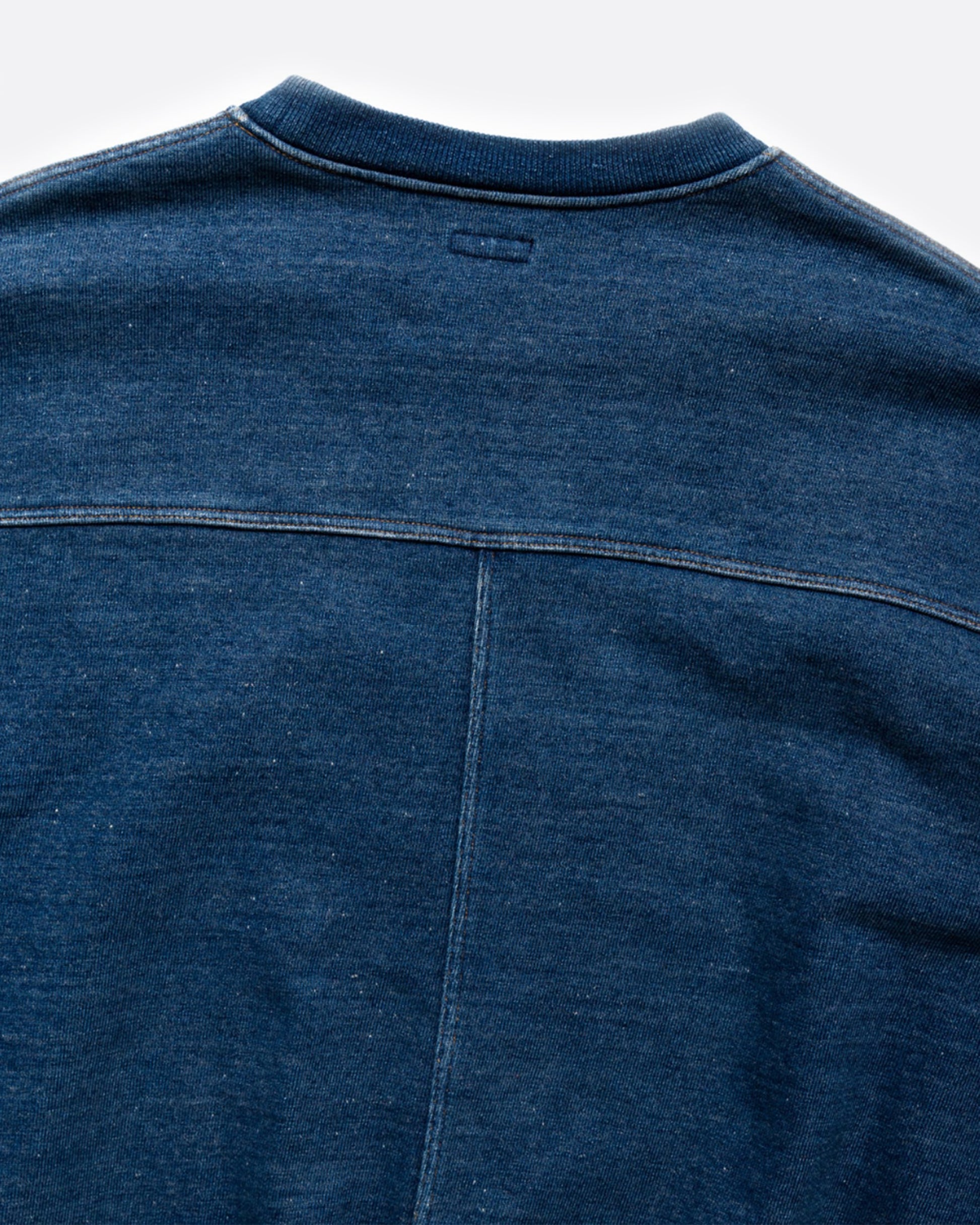 A loose fitting, indigo fleece sweatshirt with a T-shaped split back and cinch.