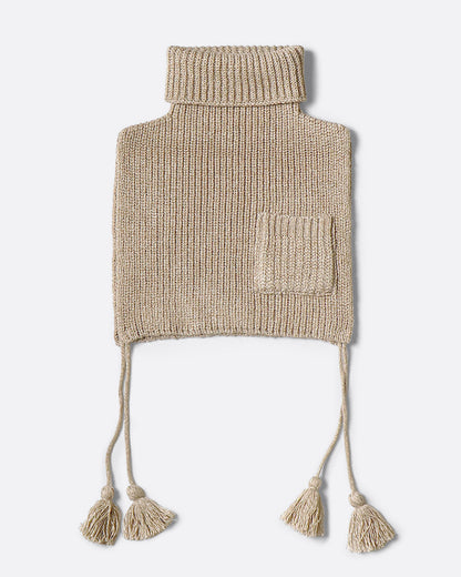 A beige loose knit bib poncho with a front pocket, long tassels, and a high neck, shown from the front. 