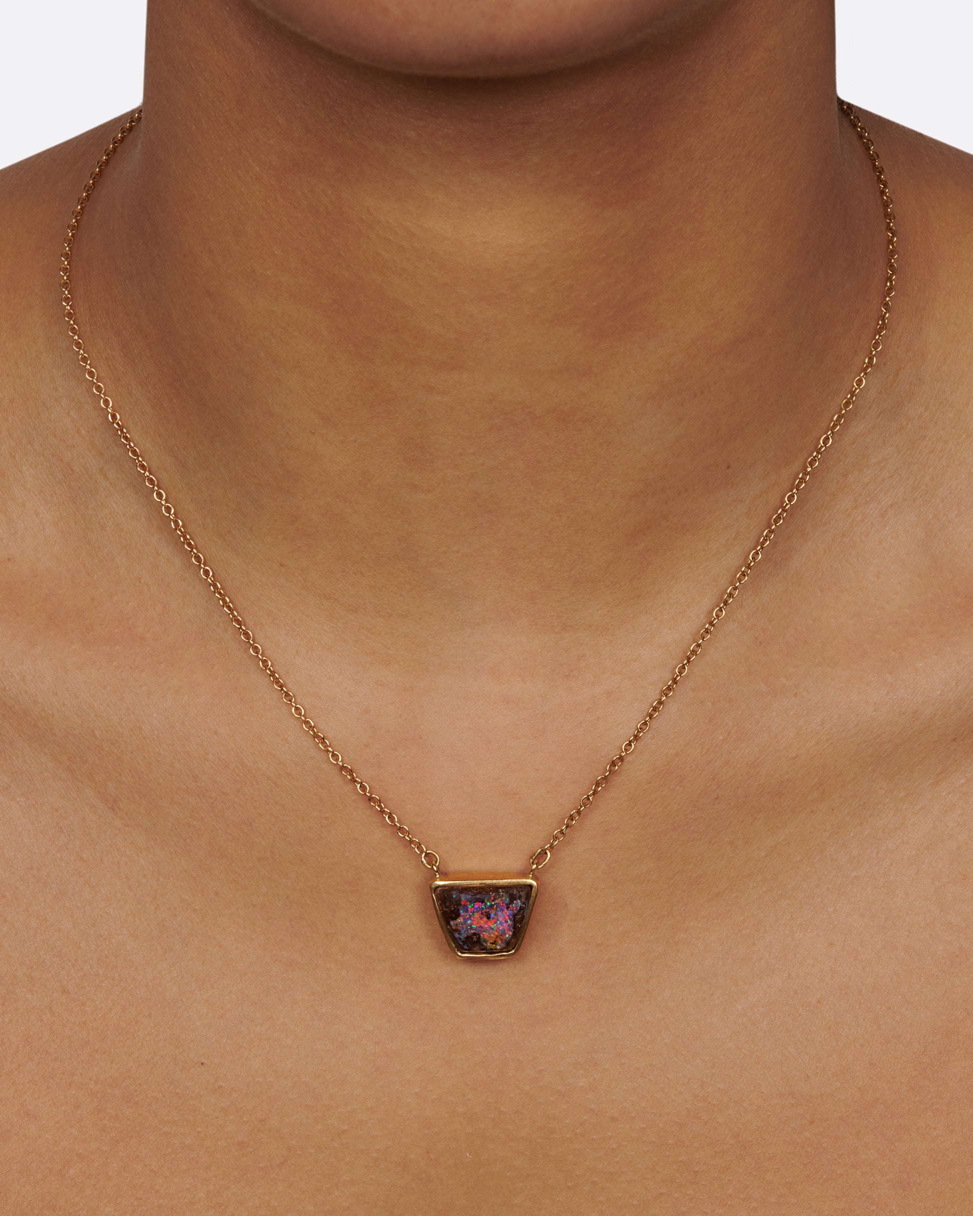 A flashy opalized wood is set in a simple bezel setting so the stone remains the star of this necklace.