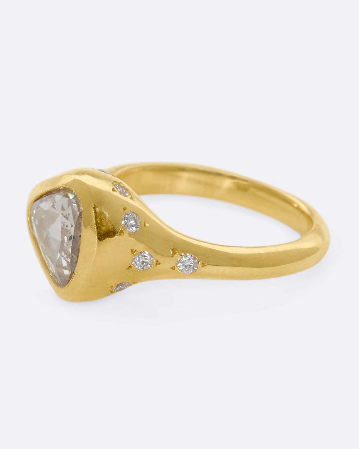 A glorious triangular, rose cut diamond sits on its side giving this ring an east-west sensibility.