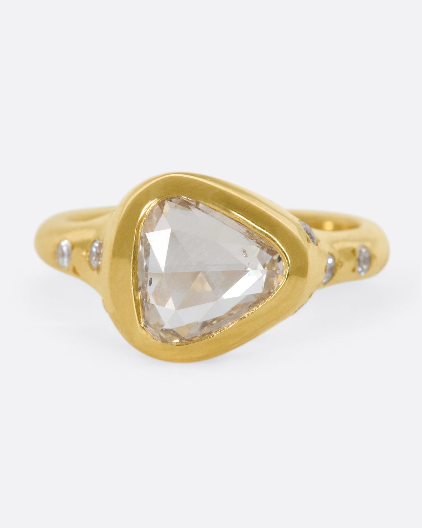 A glorious triangular, rose cut diamond sits on its side giving this ring an east-west sensibility.