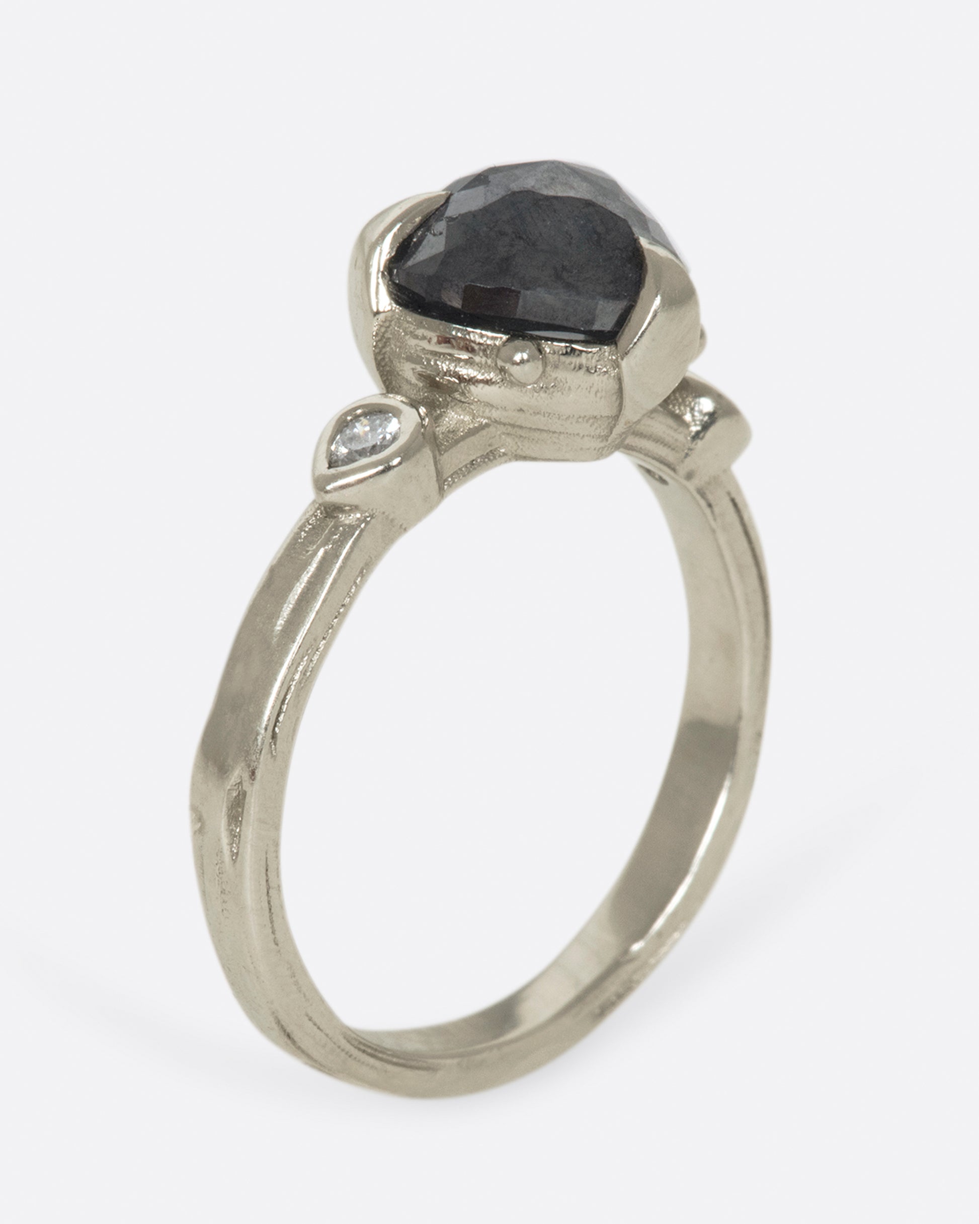 A dark, glamorous ring with a rose cut, heart-shaped diamond embraced in pointed claw settings.