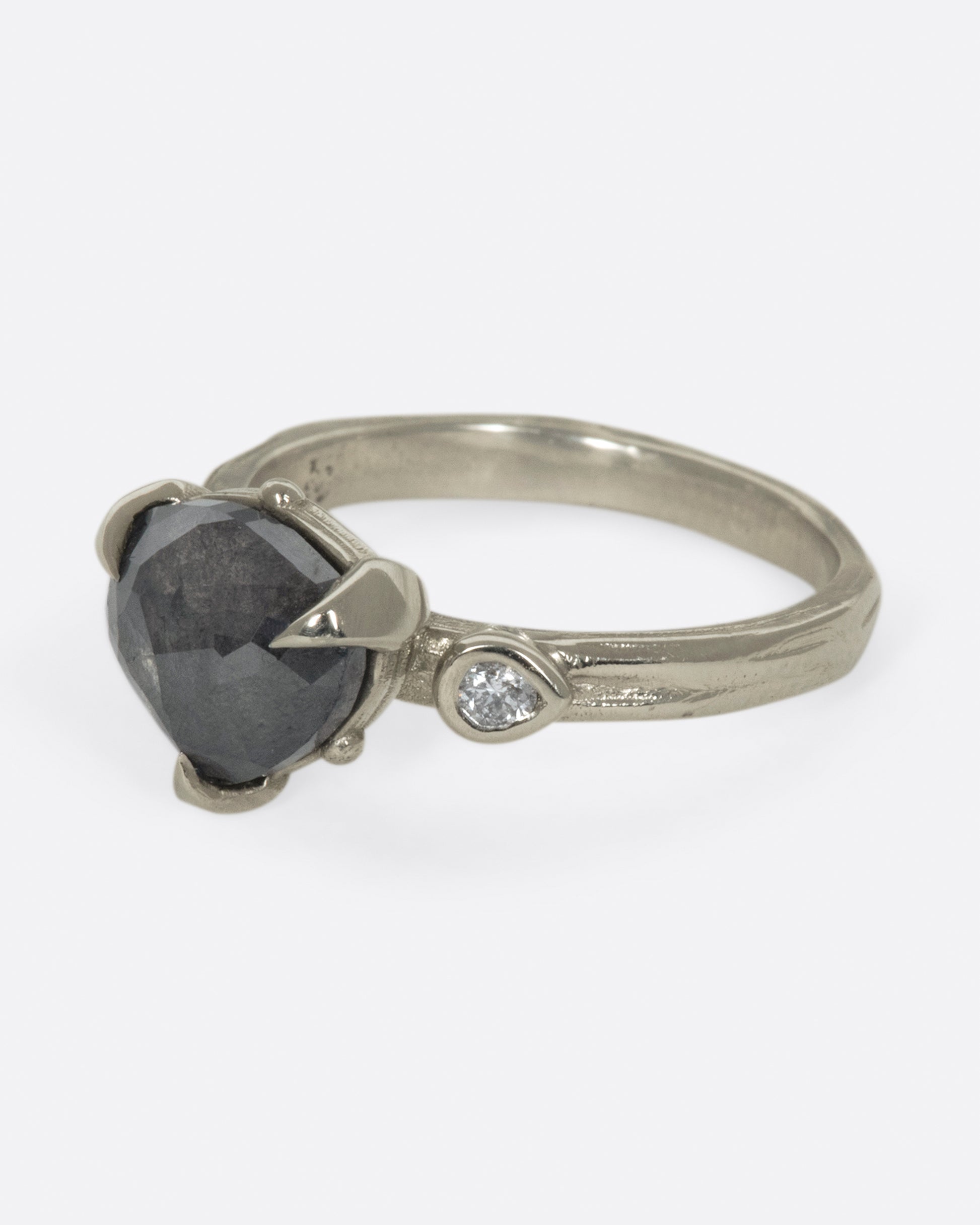 A dark, glamorous ring with a rose cut, heart-shaped diamond embraced in pointed claw settings.