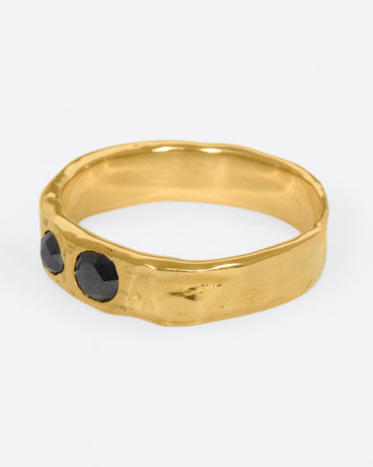 Yellow gold black diamond band, side view with the black diamonds facing left