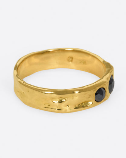 Yellow gold black diamond band, side view with the black diamonds facing right