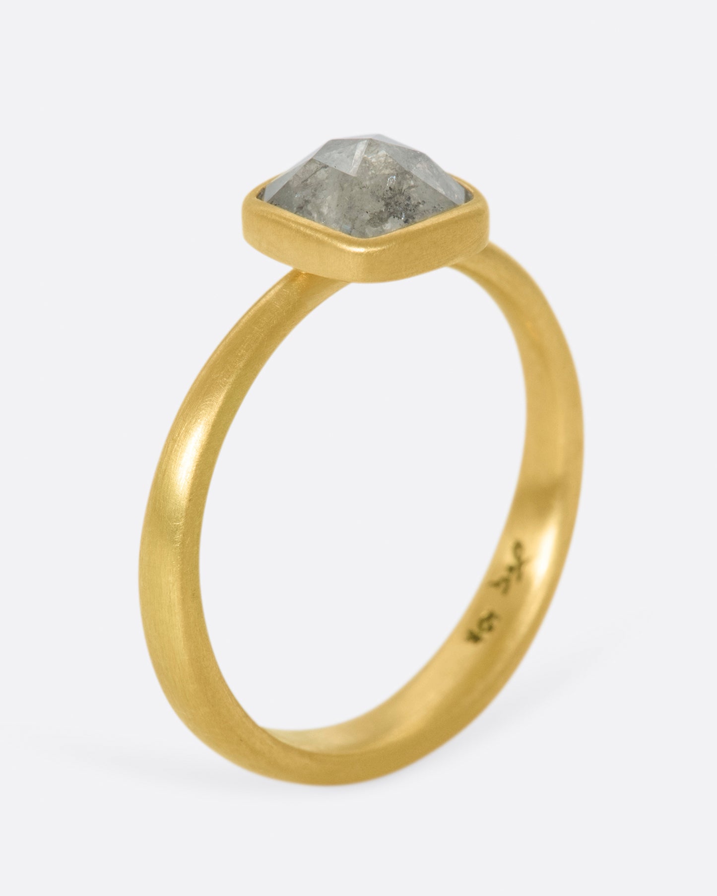 A faceted, cushion-shape diamond set in Lola Brooks' signature bezel setting