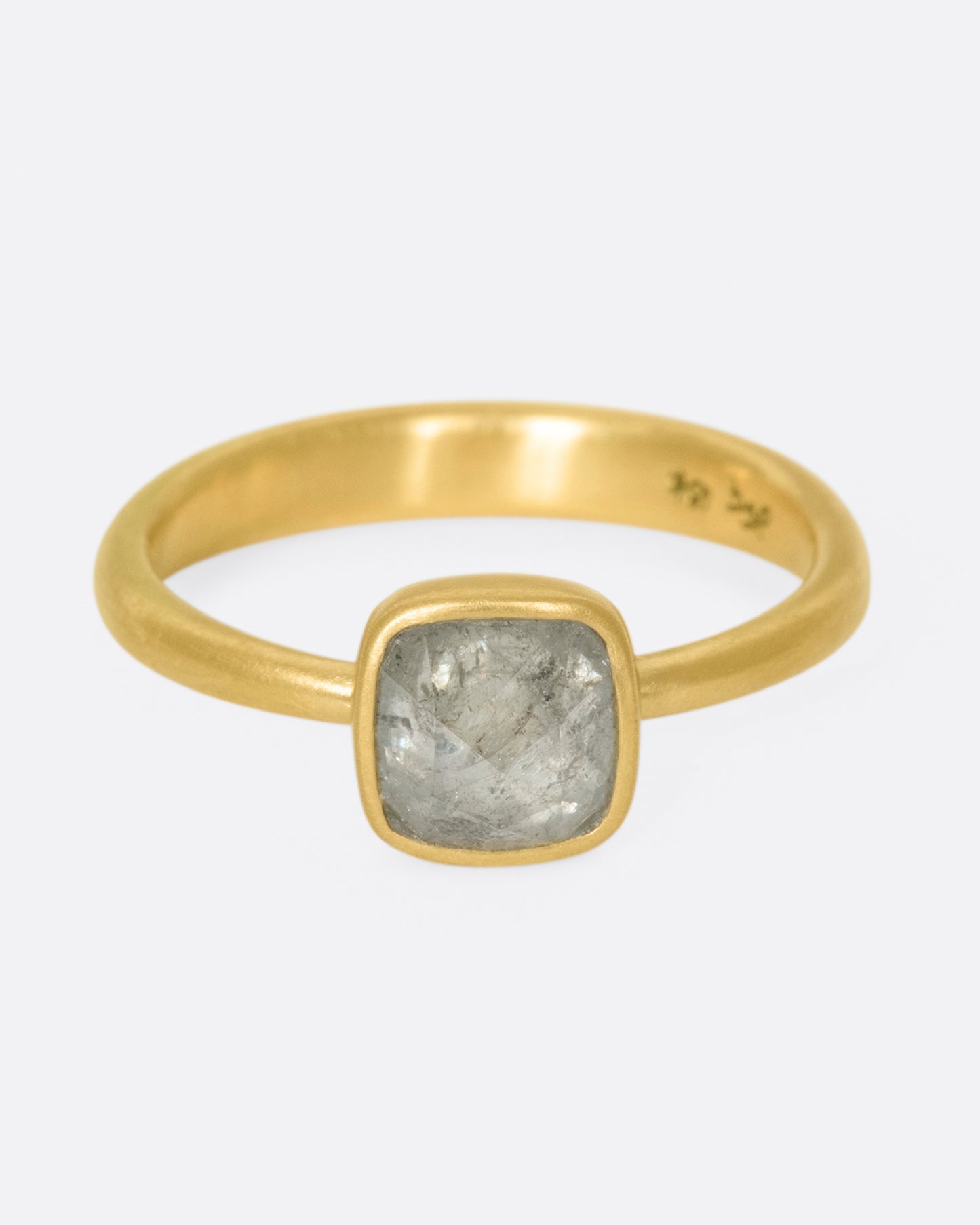 A faceted, cushion-shape diamond set in Lola Brooks' signature bezel setting